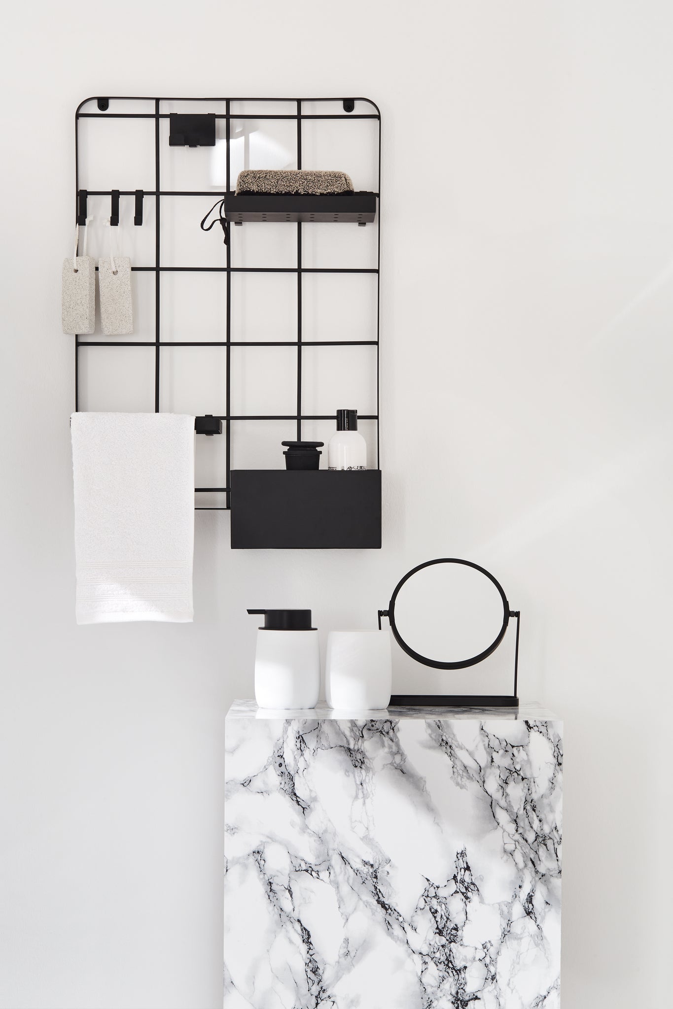 Zahnputzbecher BONNY Weiß stehen mit Spiegel auf marmorierter Ablage im Bad.