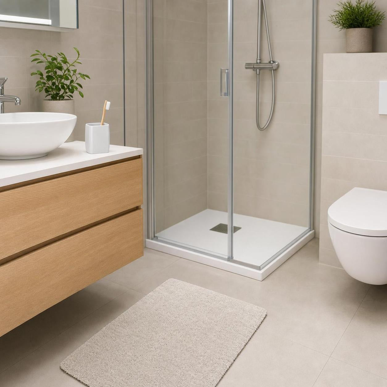 Ein beiger Badteppich liegt vor der Dusche im modernen Badezimmer.