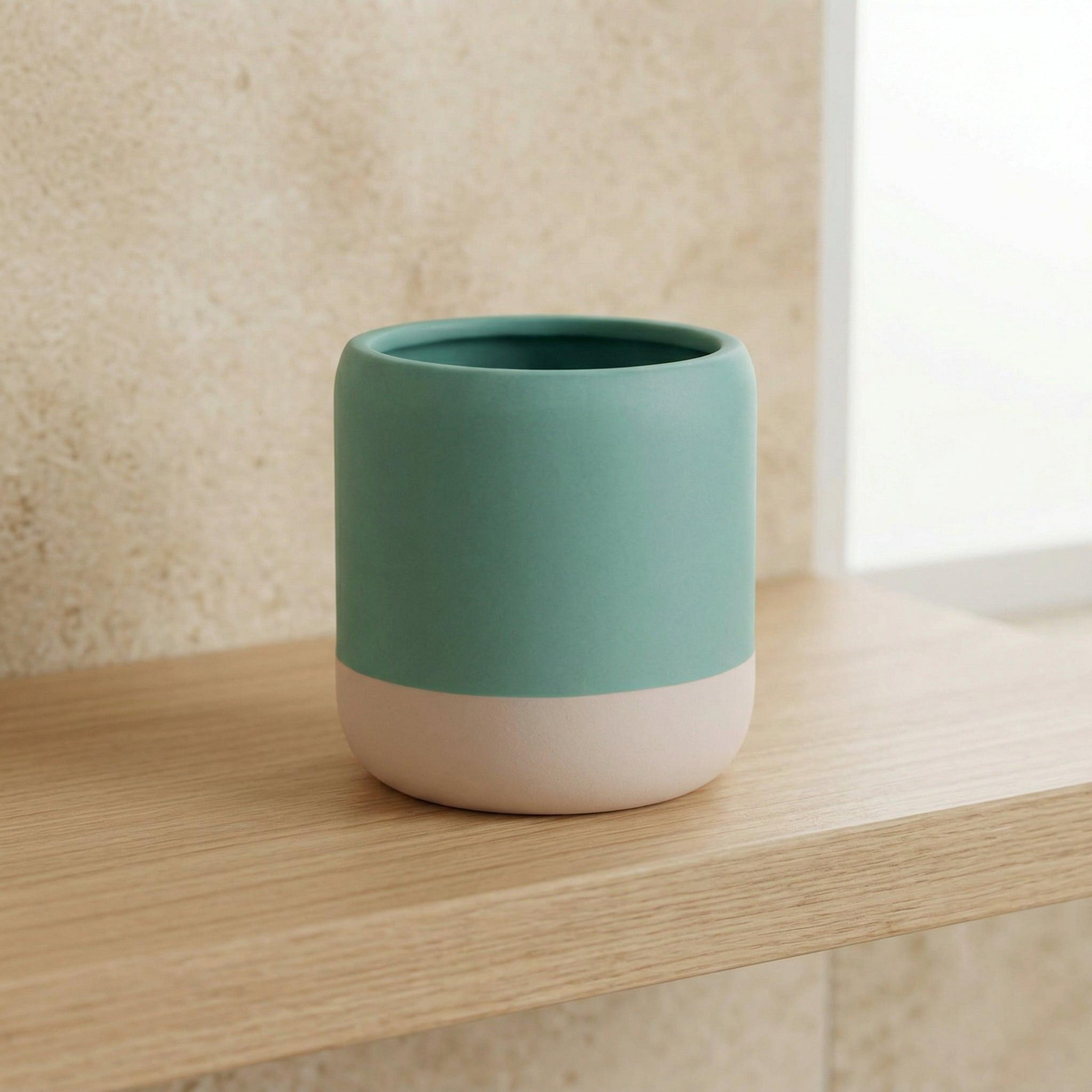 Zylindrischer Becher aus Keramik in Mintgrün und Beige auf Holzablage