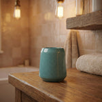 Türkisfarbener Zahnputzbecher aus Keramik auf rustikalem Holztisch