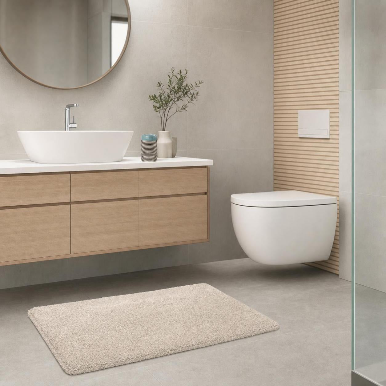 Beiger Badteppich liegt vor Waschbecken und WC im modernen Bad.