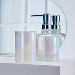 Irideszierender Seifenspender mit passendem Becher vor Spiegel im Bad