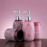 Rosa Badezimmerset mit Spendern und Bechern auf spiegelnder Fläche