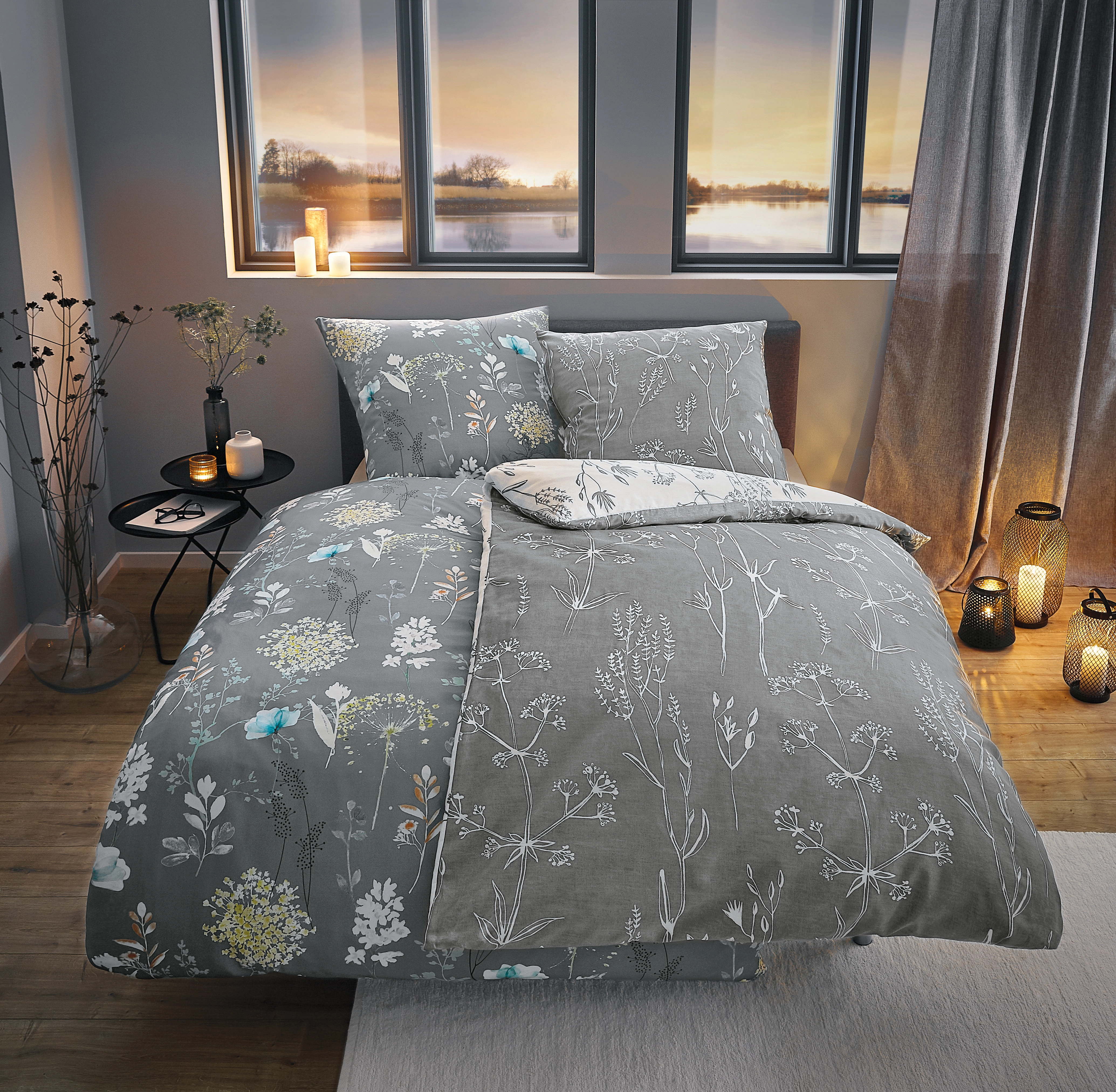 Bettwäsche-Set in Grau mit floralen Mustern, gemütlich dekoriert in einem modernen Schlafzimmer mit Blick auf den Sonnenuntergang.