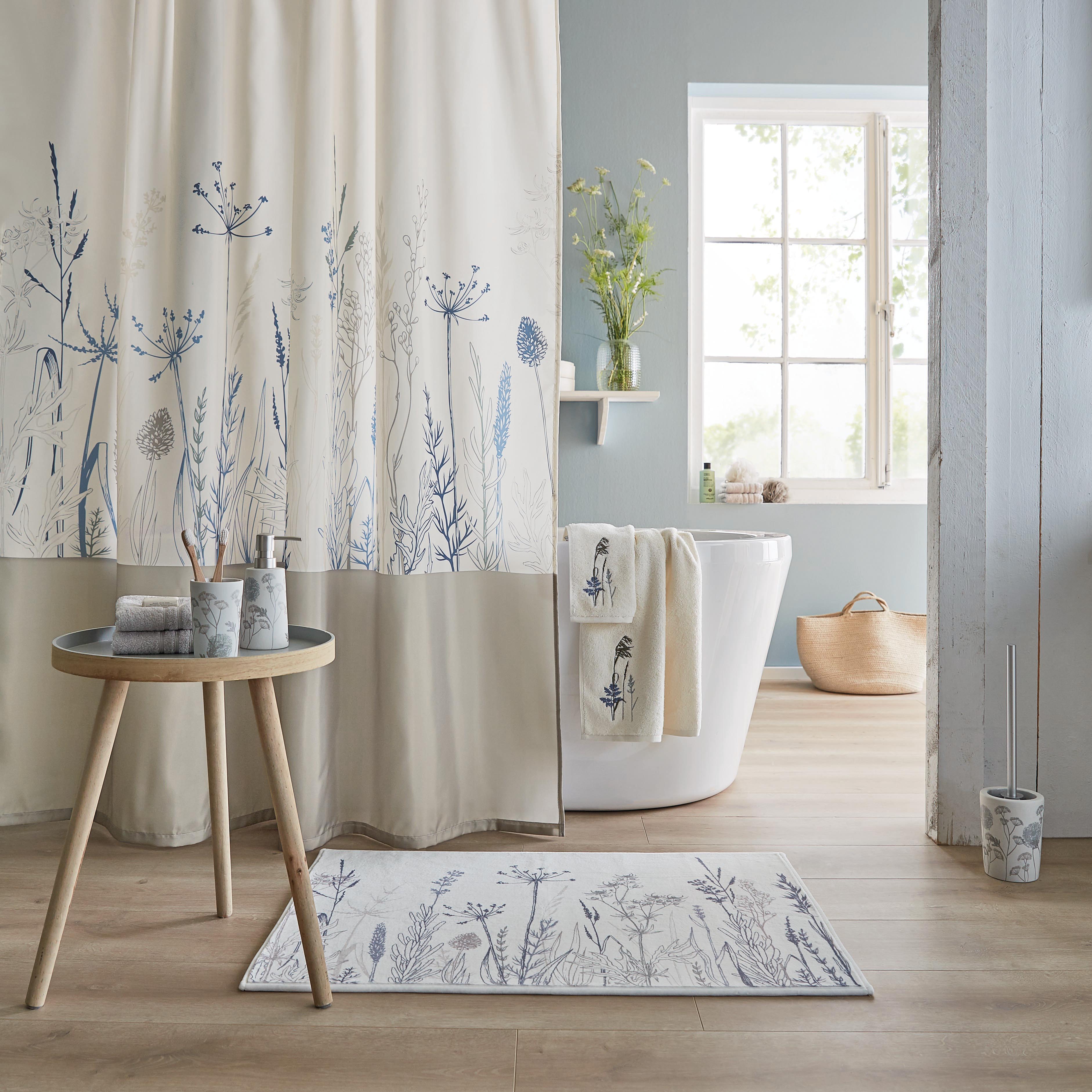 Badezimmer im Landhausstil mit floraler Duschvorhang, passendem Teppich und Handtüchern, helle und freundliche Atmosphäre.