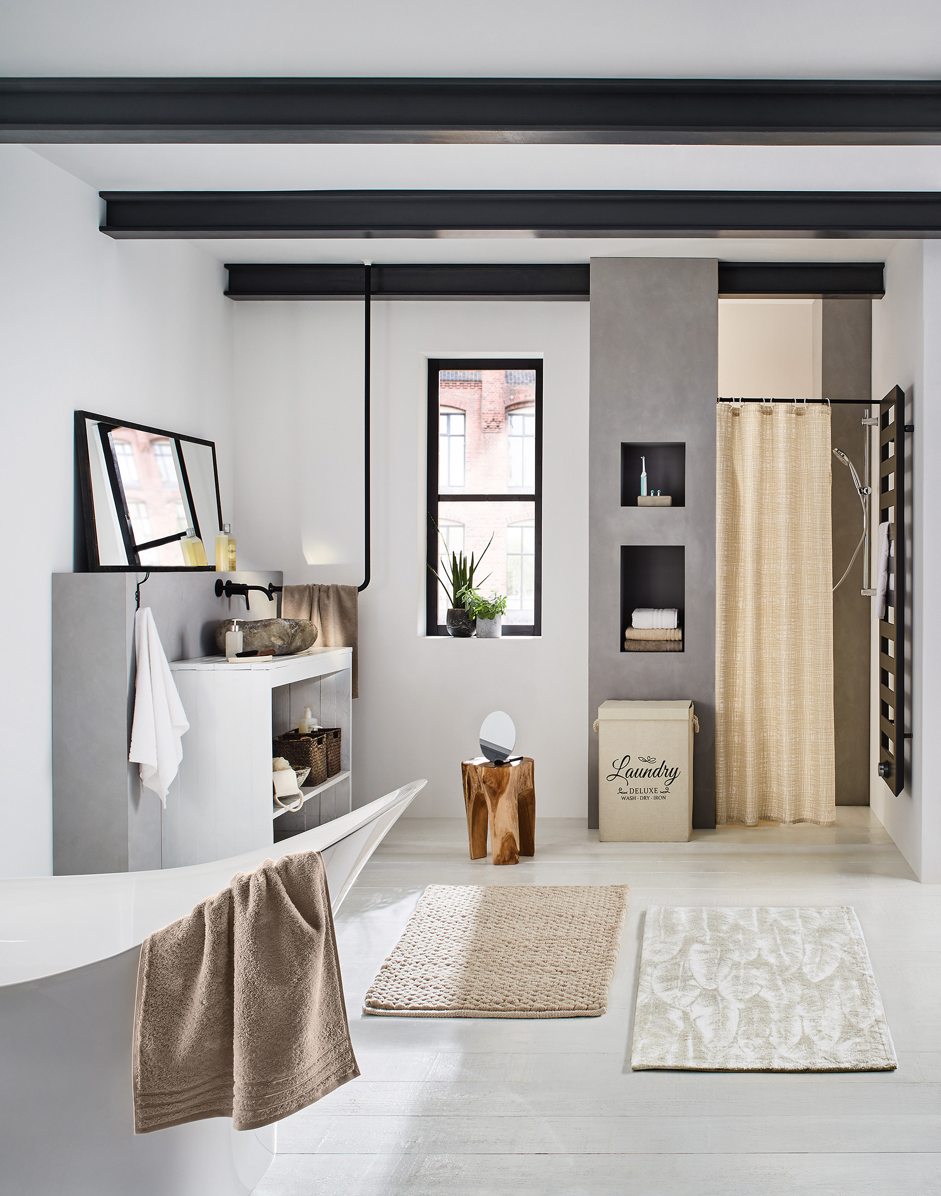 Modernes Badezimmer mit freistehender Badewanne, stilvollen Accessoires und natürlicher Dekoration in hellen Farben.