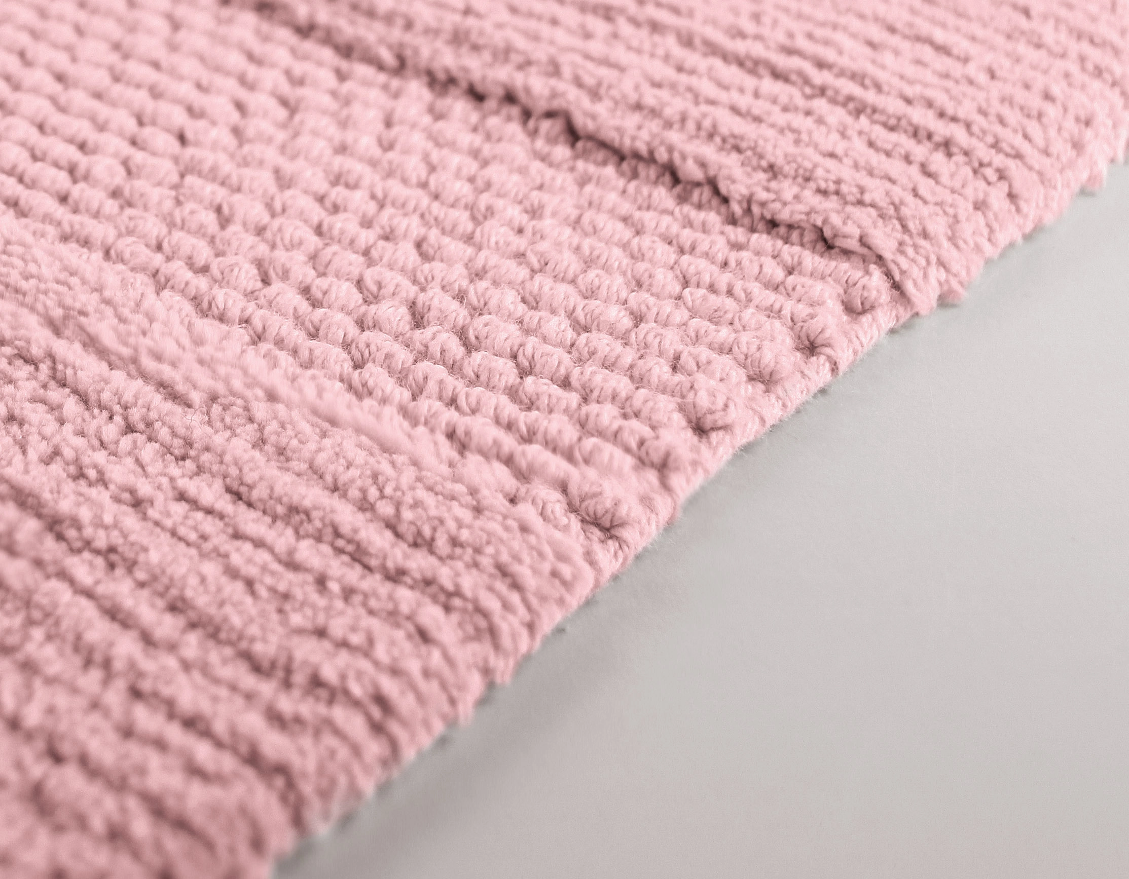 Weiche, rosa Badematte mit strukturierter Oberfläche und rutschfester Unterseite für ein komfortables Badeerlebnis.