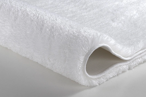 Weißer, flauschiger Badteppich mit rutschfester Unterseite, ideal für ein komfortables und sicheres Badeerlebnis.