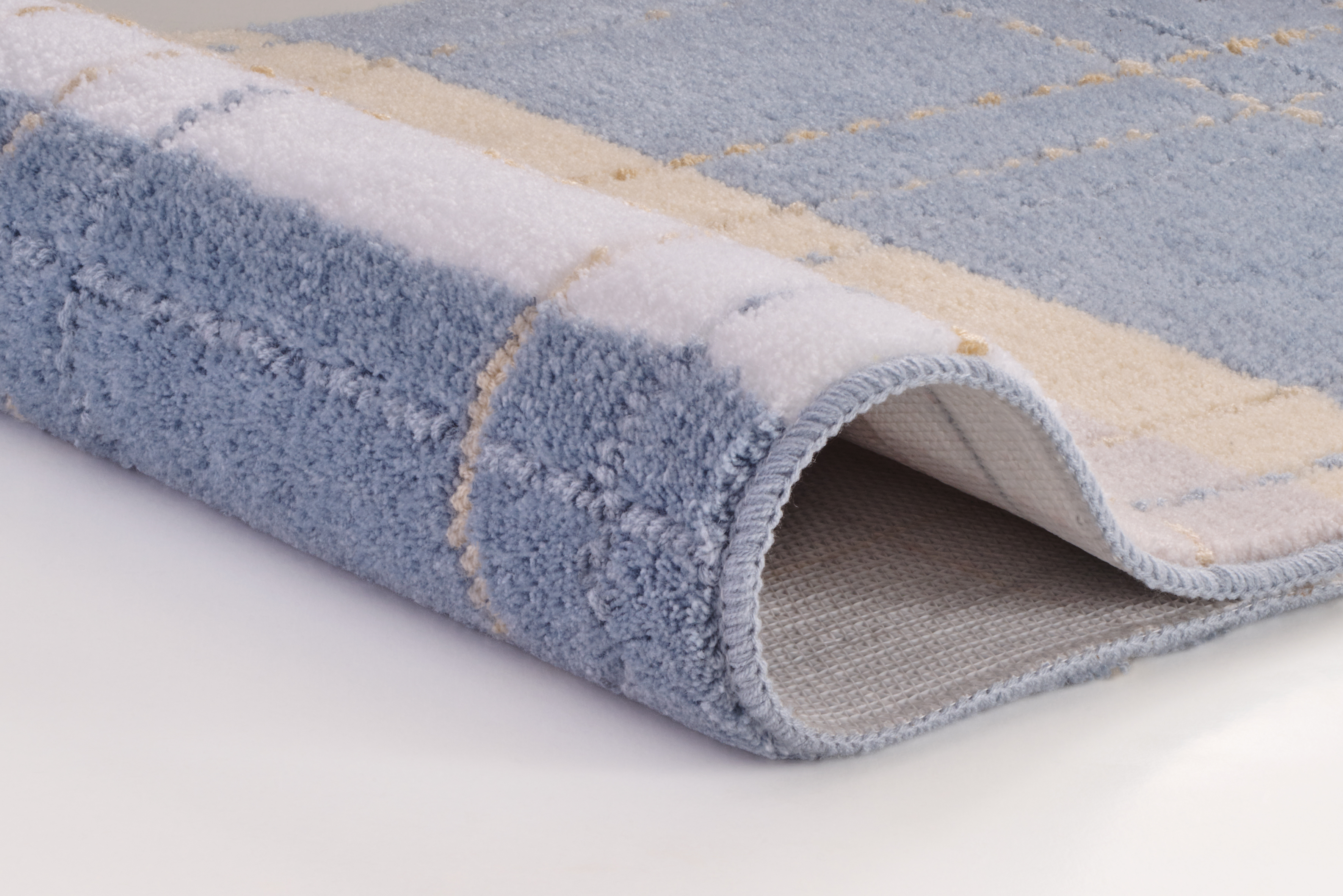 Weicher, blau-weiß karierter Teppich mit beigem Akzent, ideal für gemütliche Wohnräume.