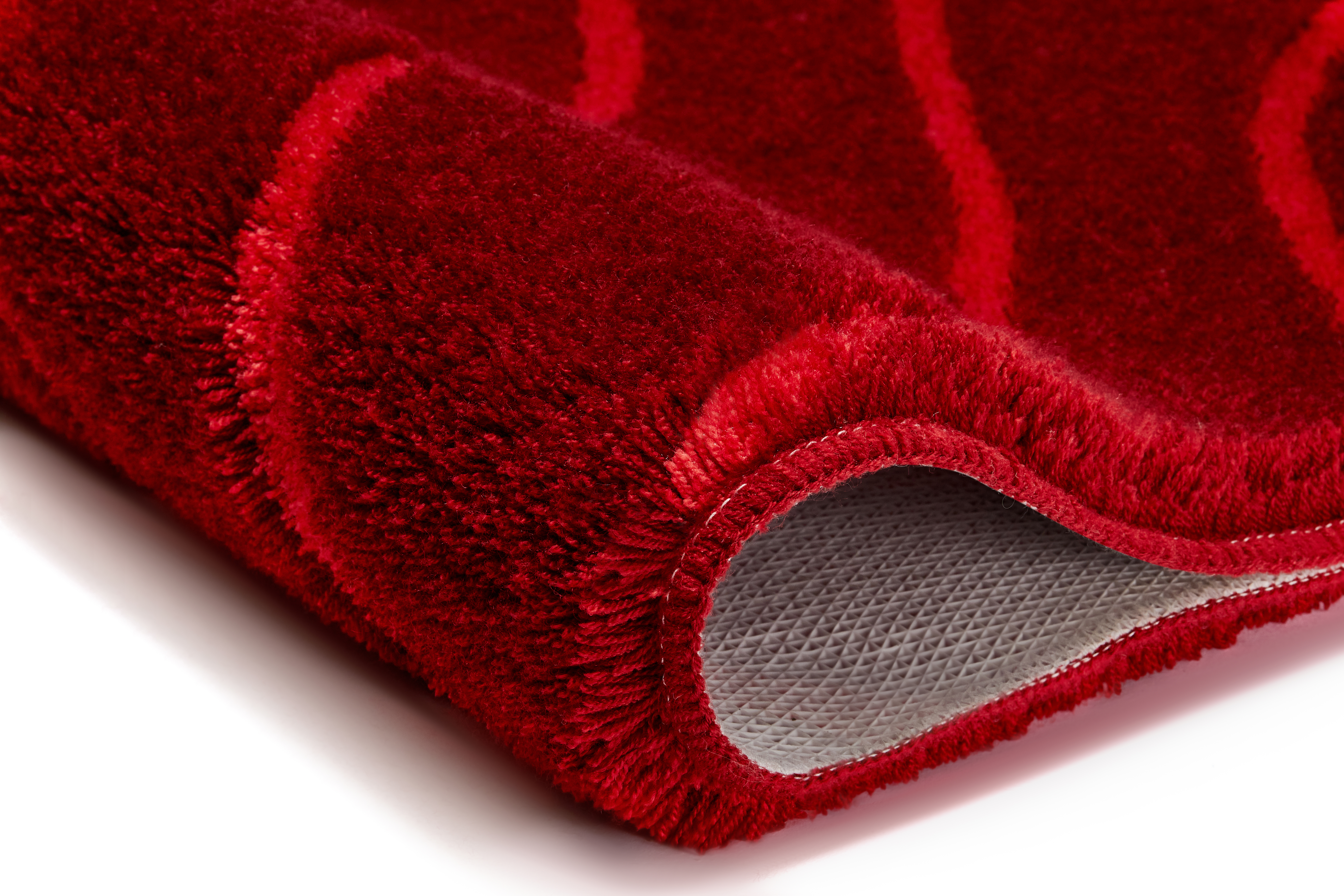 Roter Teppich mit weicher, flauschiger Oberfläche und rutschfester Unterseite, ideal für Wohn- und Schlafzimmer.