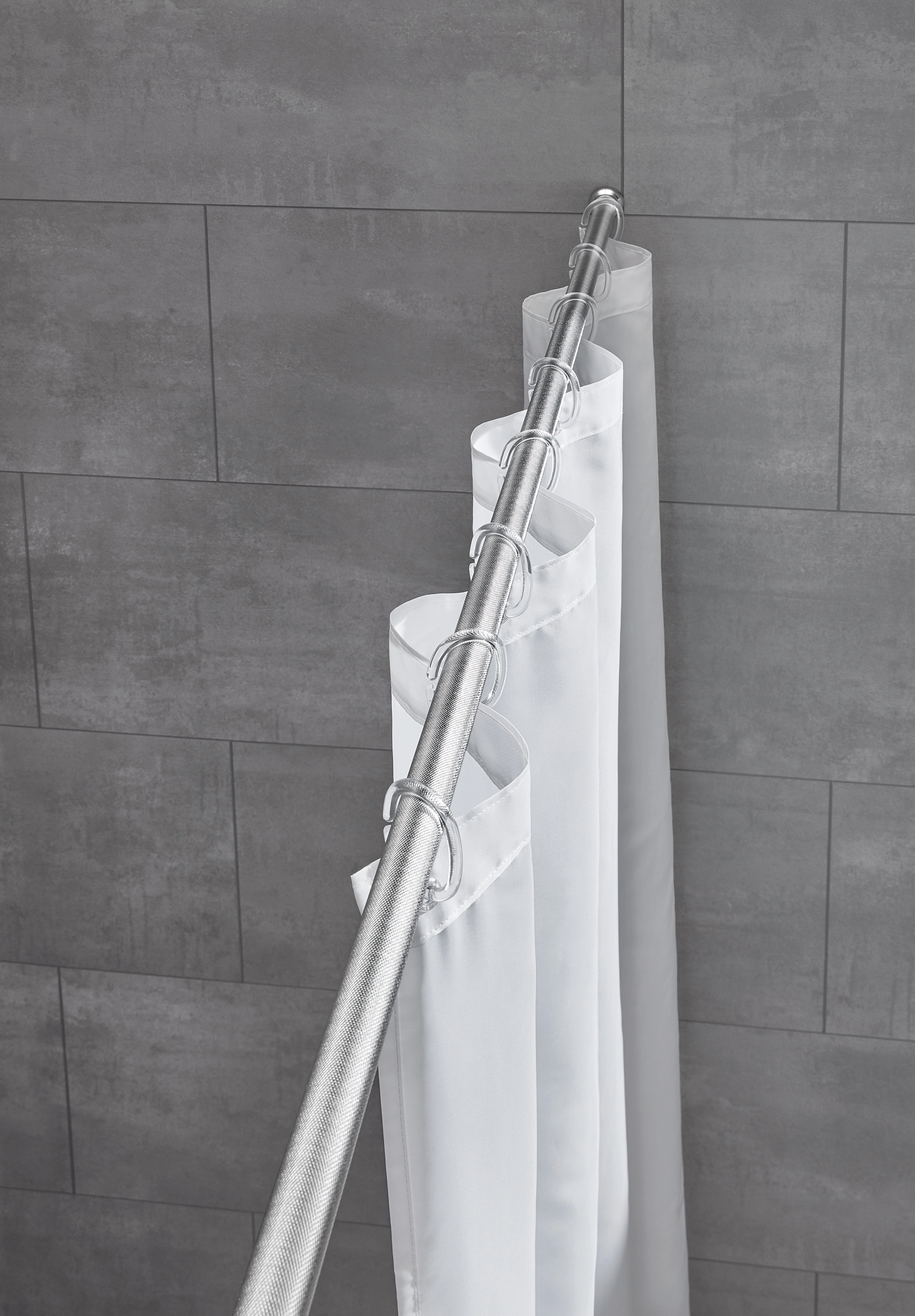 Duschvorhangstange aus Edelstahl mit strukturierter Oberfläche, montiert in einer modernen grauen Fliesenwand.