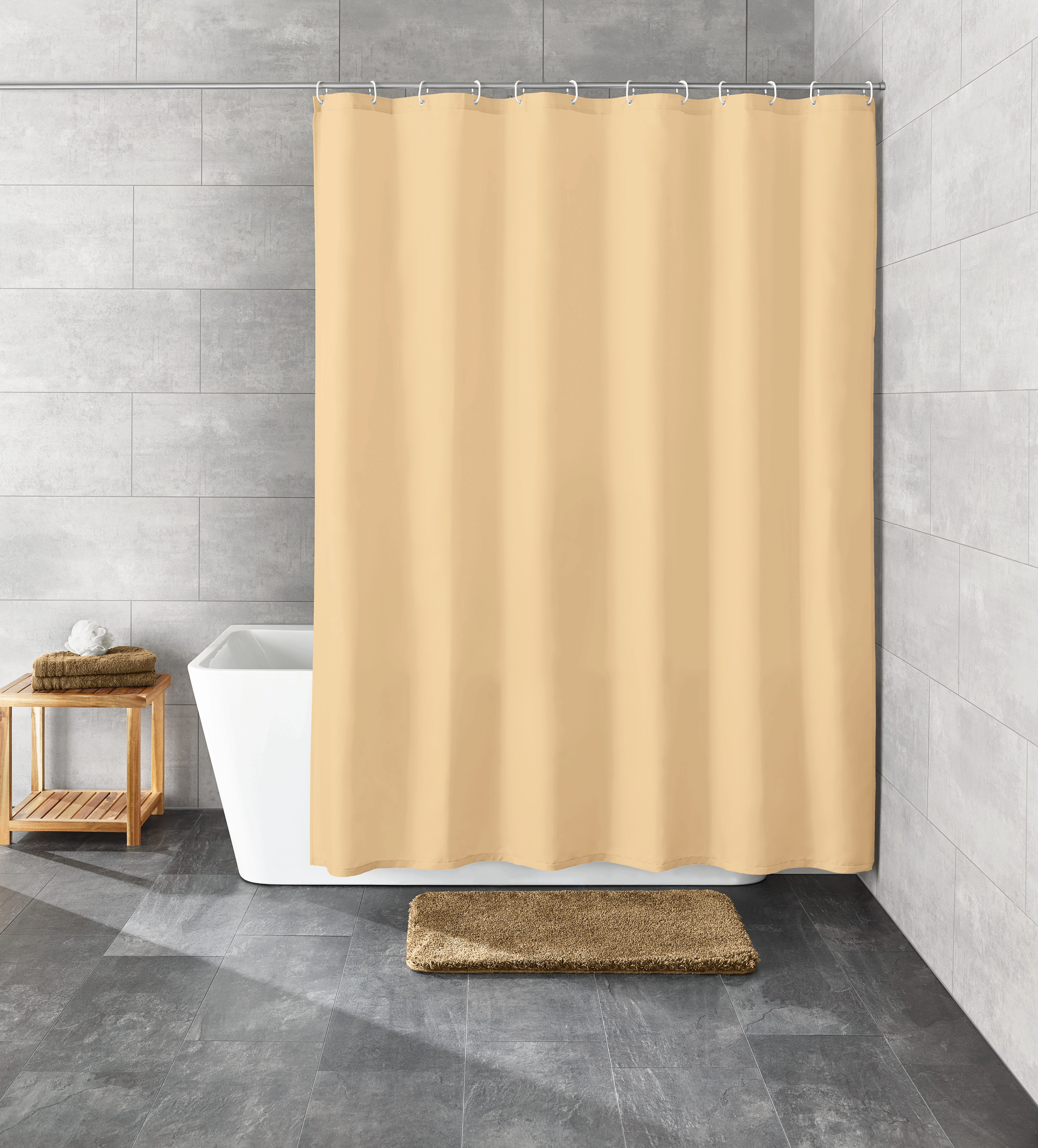 Beiger Duschvorhang in modernem Badezimmer mit grauen Fliesen, Badewanne, Holzregal und passendem Badteppich.
