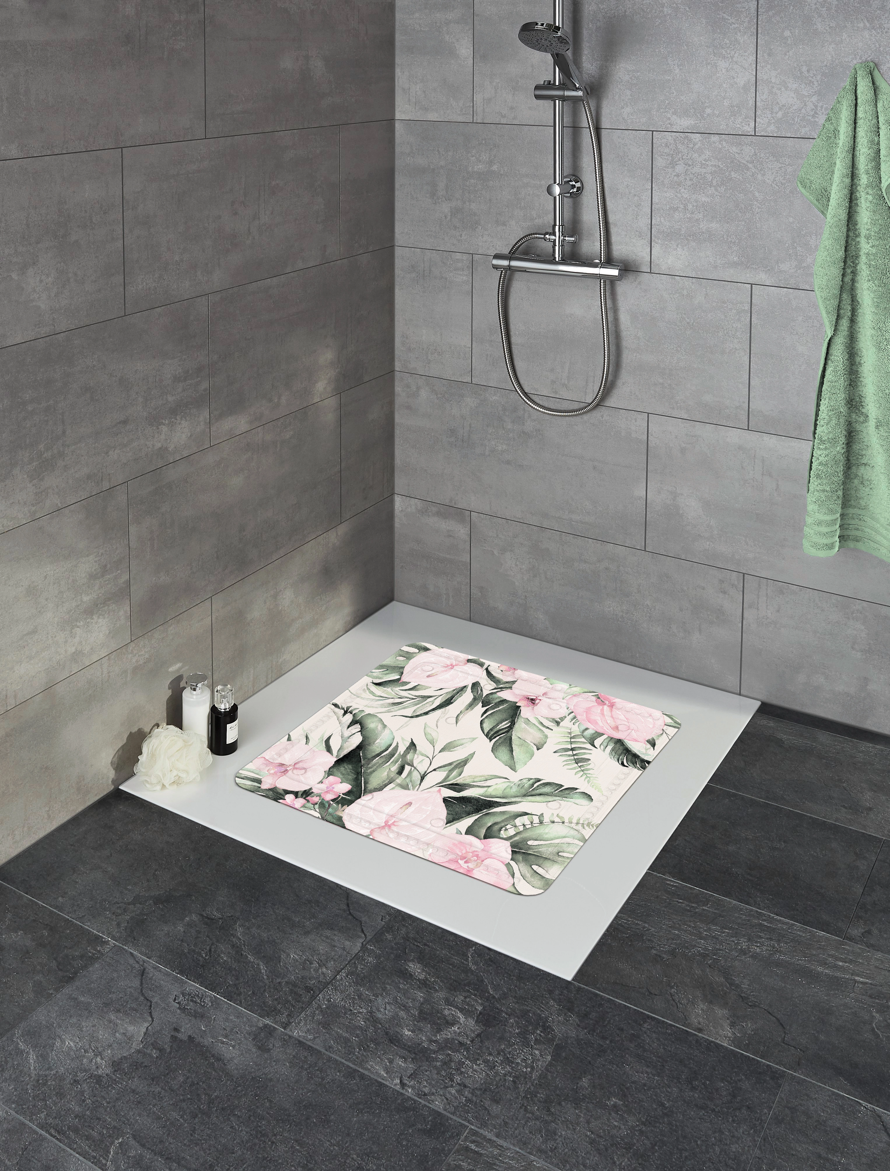 Duschmatte mit floralem Design in einer modernen grauen Badezimmerumgebung, neben einer grünen Handtuch.