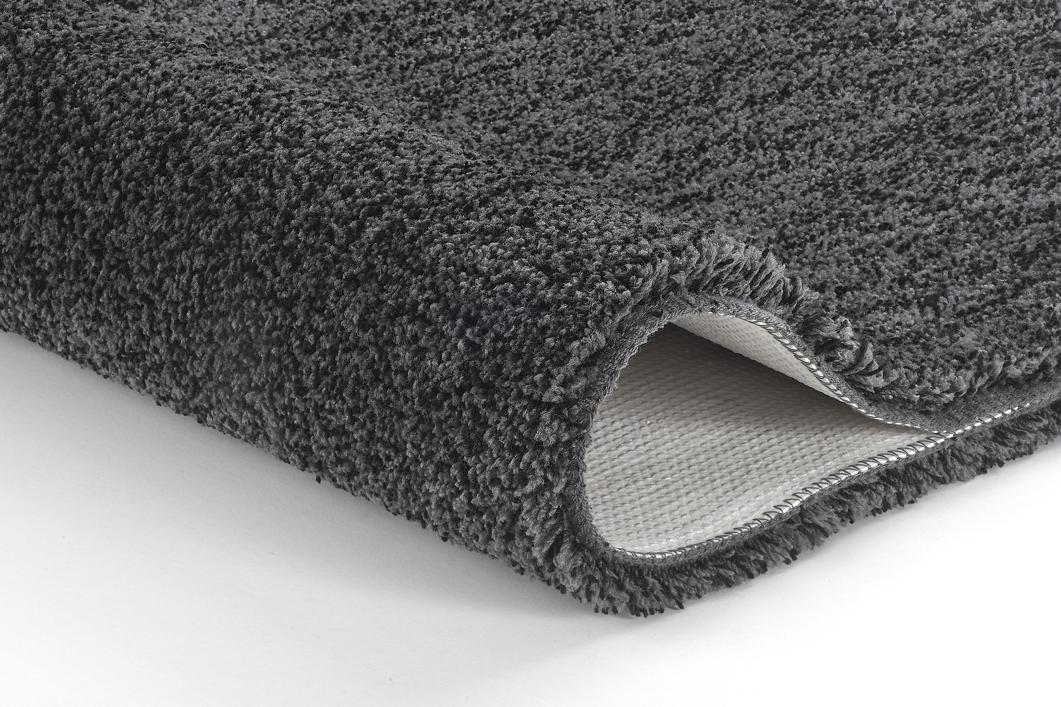 Weicher, dunkelgrauer Badteppich mit rutschfester Unterseite, ideal für ein modernes Badezimmer.