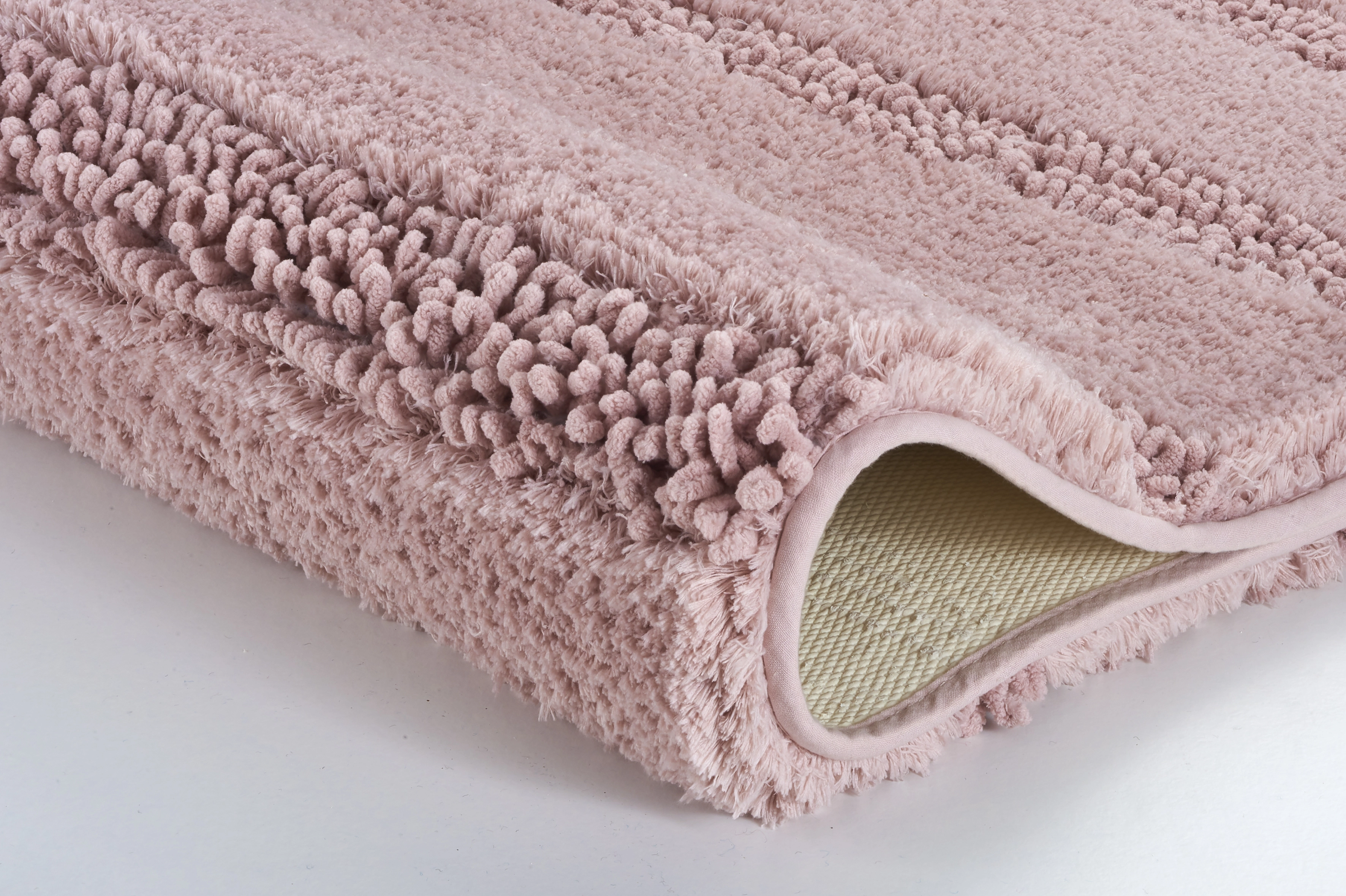 Rosa Badematte mit weicher, flauschiger Oberfläche und rutschfester Unterseite, ideal für ein gemütliches Badezimmer.