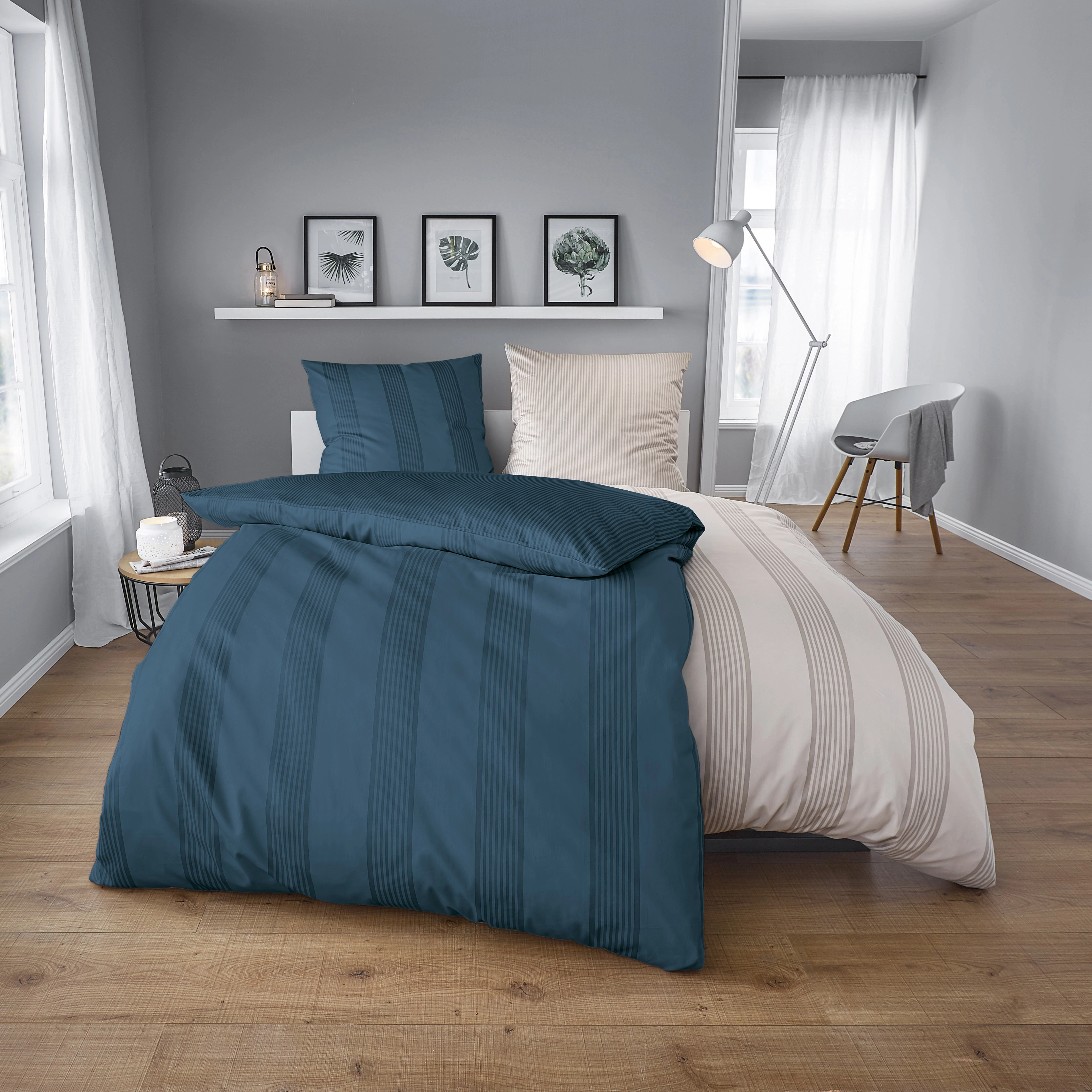 Elegante Bettwäsche in Blau und Beige mit Streifenmuster, modernes Schlafzimmer mit Holzfußboden und stilvoller Dekoration.