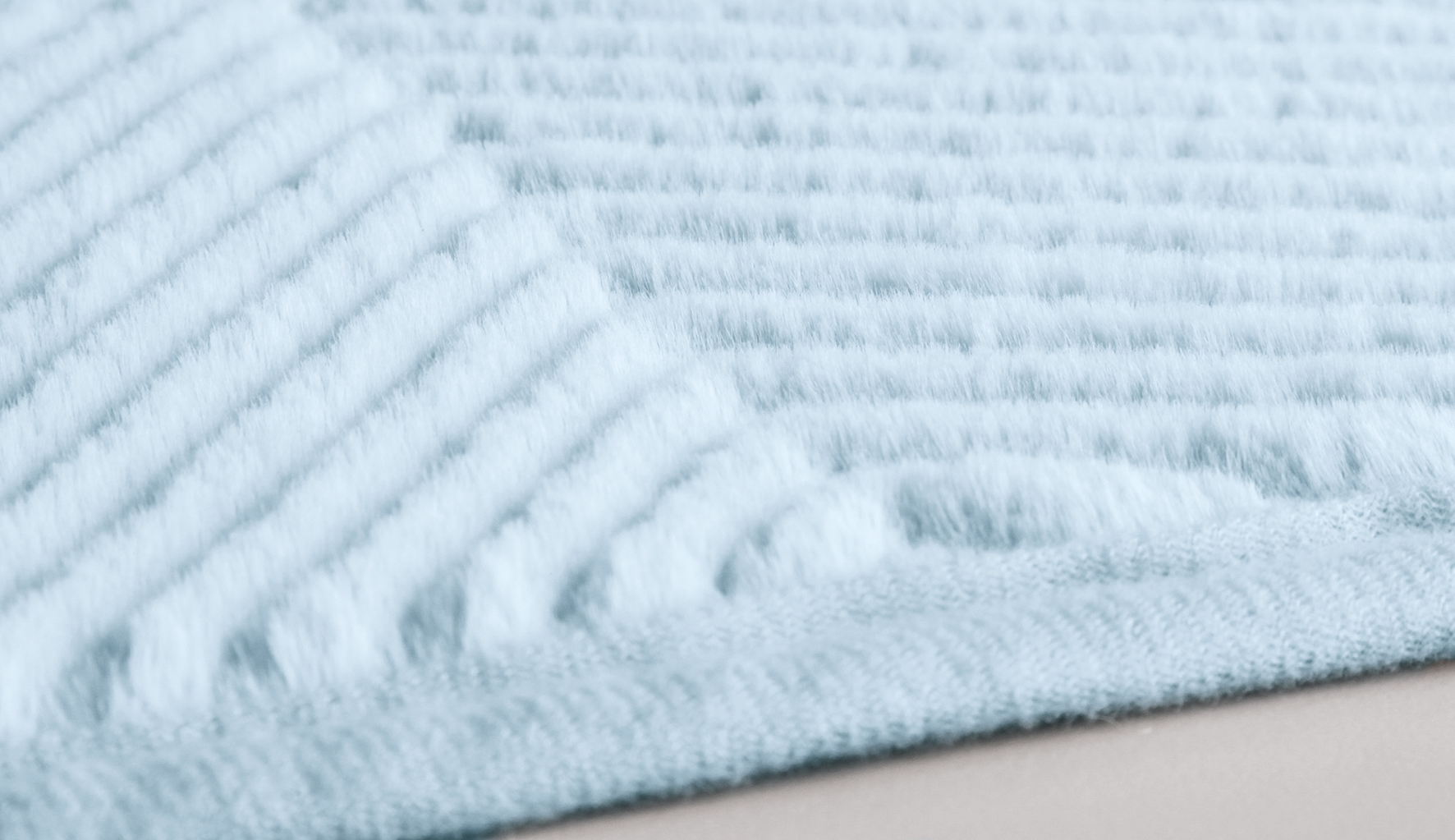 Weicher, hellblauer Badteppich mit geripptem Muster und flauschiger Textur für ein komfortables Badeerlebnis.