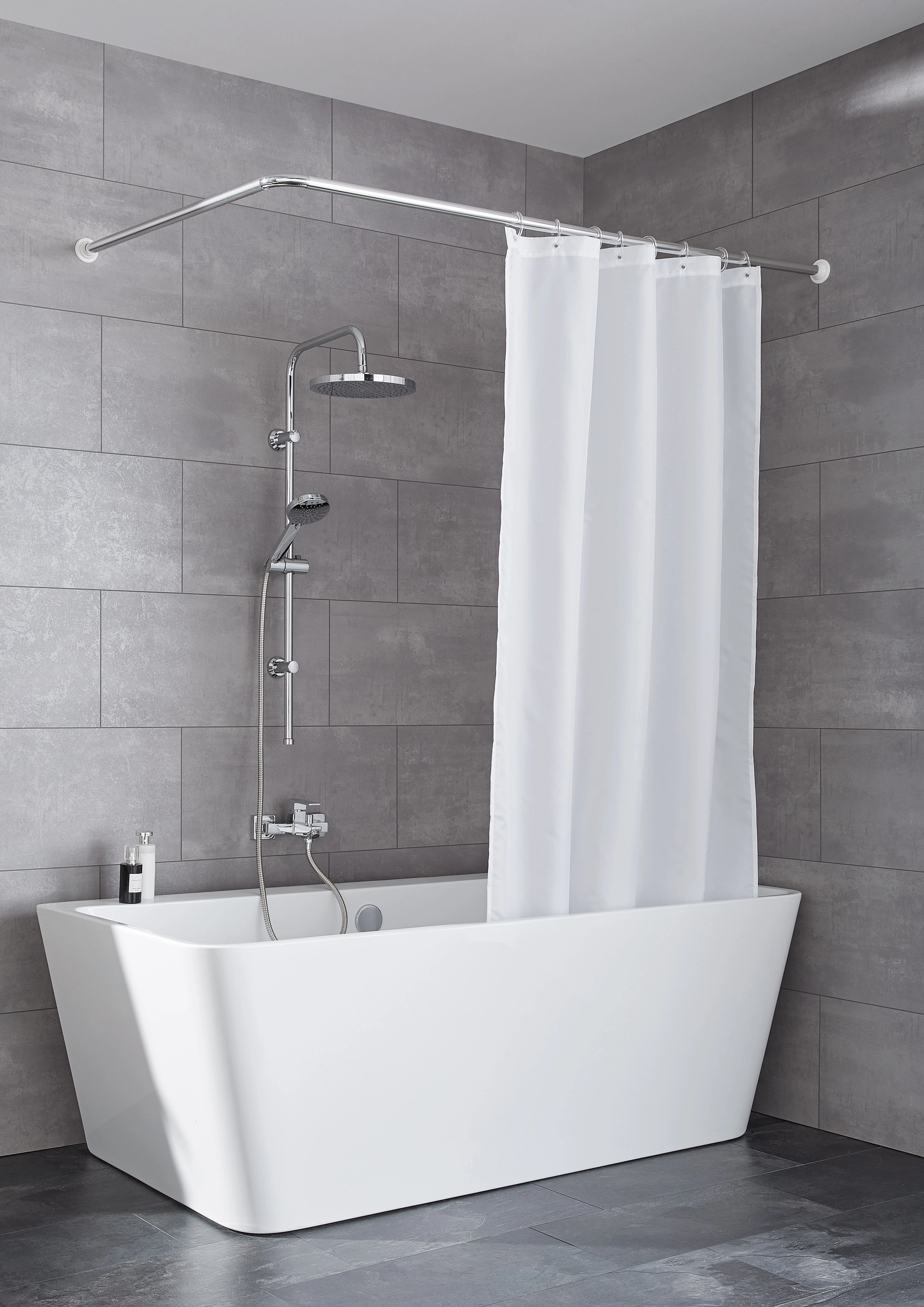 Duschvorhangstange in L-Form, verchromt, montiert über einer modernen Badewanne mit grauen Fliesen im Hintergrund.