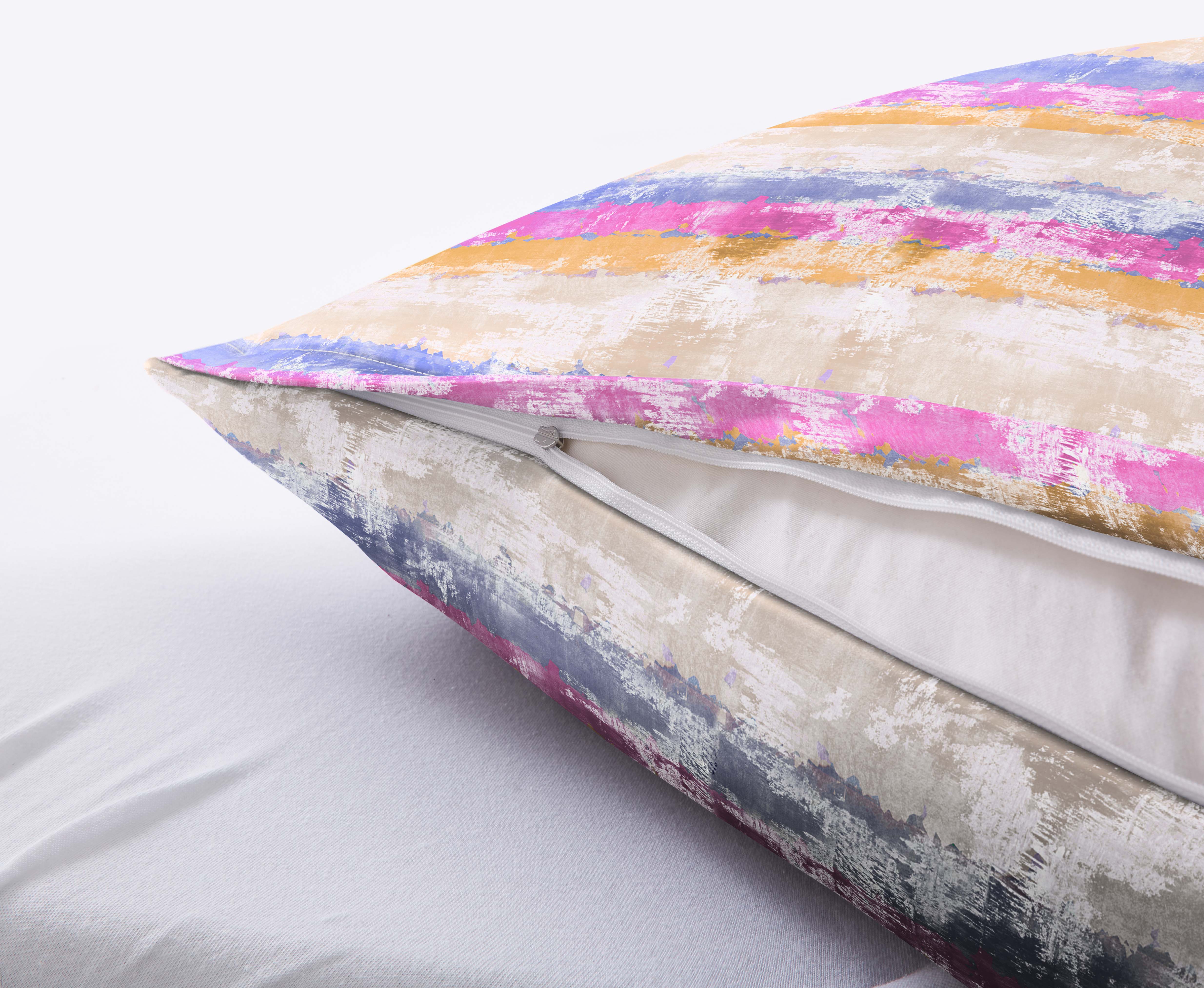 Bunte Kissenhülle mit Reißverschluss, abstraktes Streifenmuster in Pink, Blau, Gelb und Weiß, auf einem weißen Bett.