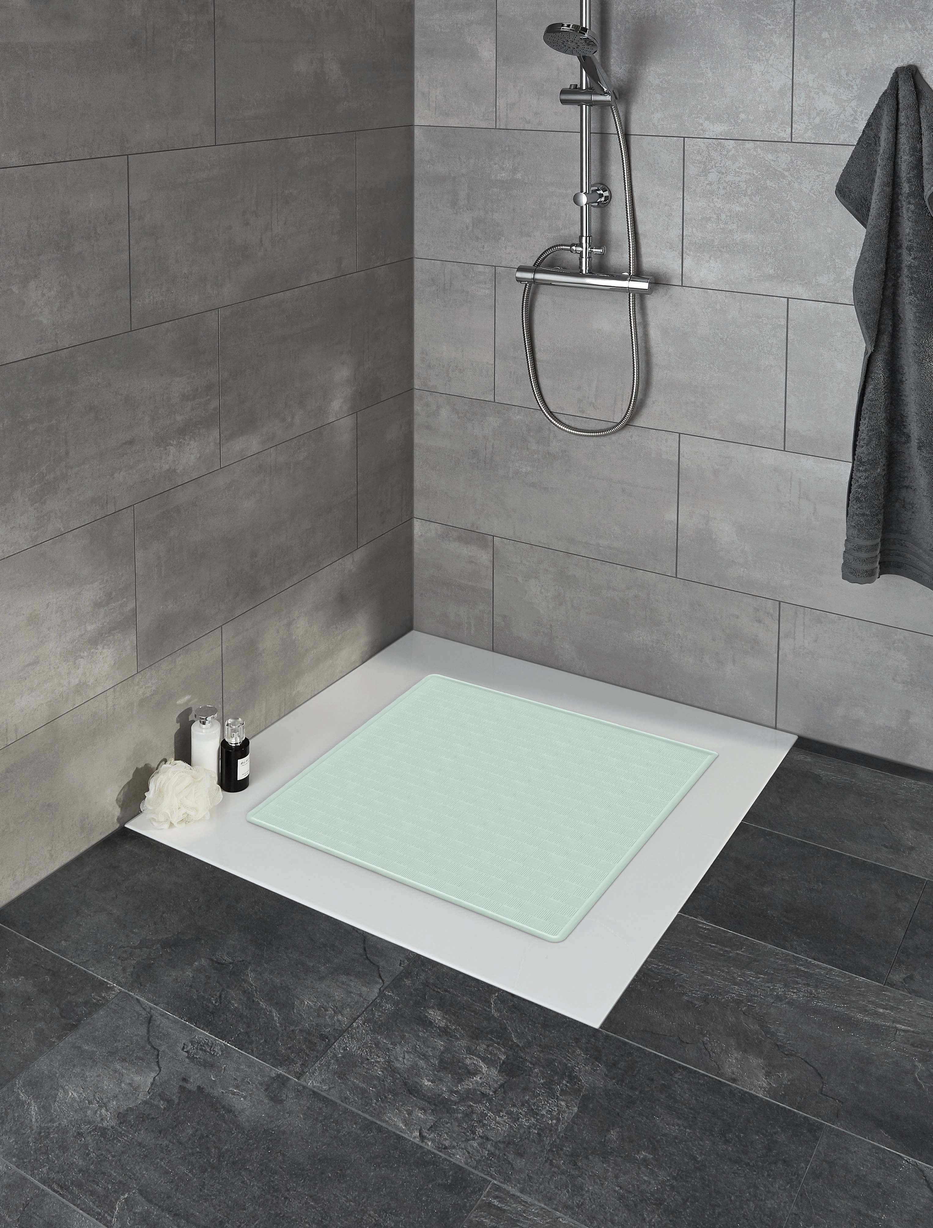 Rutschfeste Duschmatte in Mintgrün, platziert in einer modernen, grauen Dusche mit Fliesenwänden und -boden.