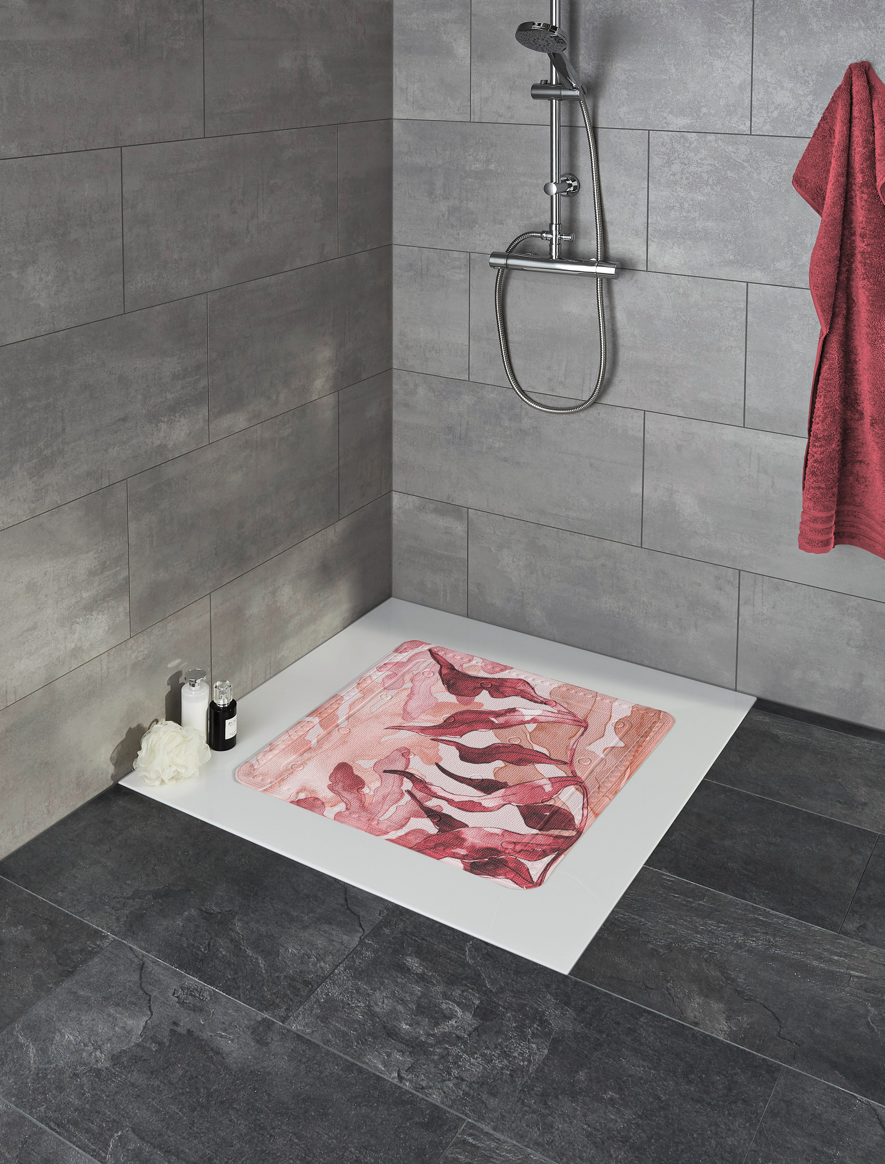 Rutschfeste Duschmatte mit modernem, abstraktem Design in Rot- und Rosatönen, platziert in einer stilvollen, grauen Dusche.