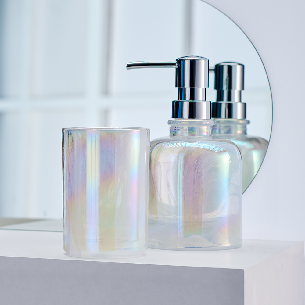 Seifenspender und Zahnputzbecher in schimmerndem Opal-Design, stilvoll arrangiert vor einem Spiegel im modernen Badezimmer.