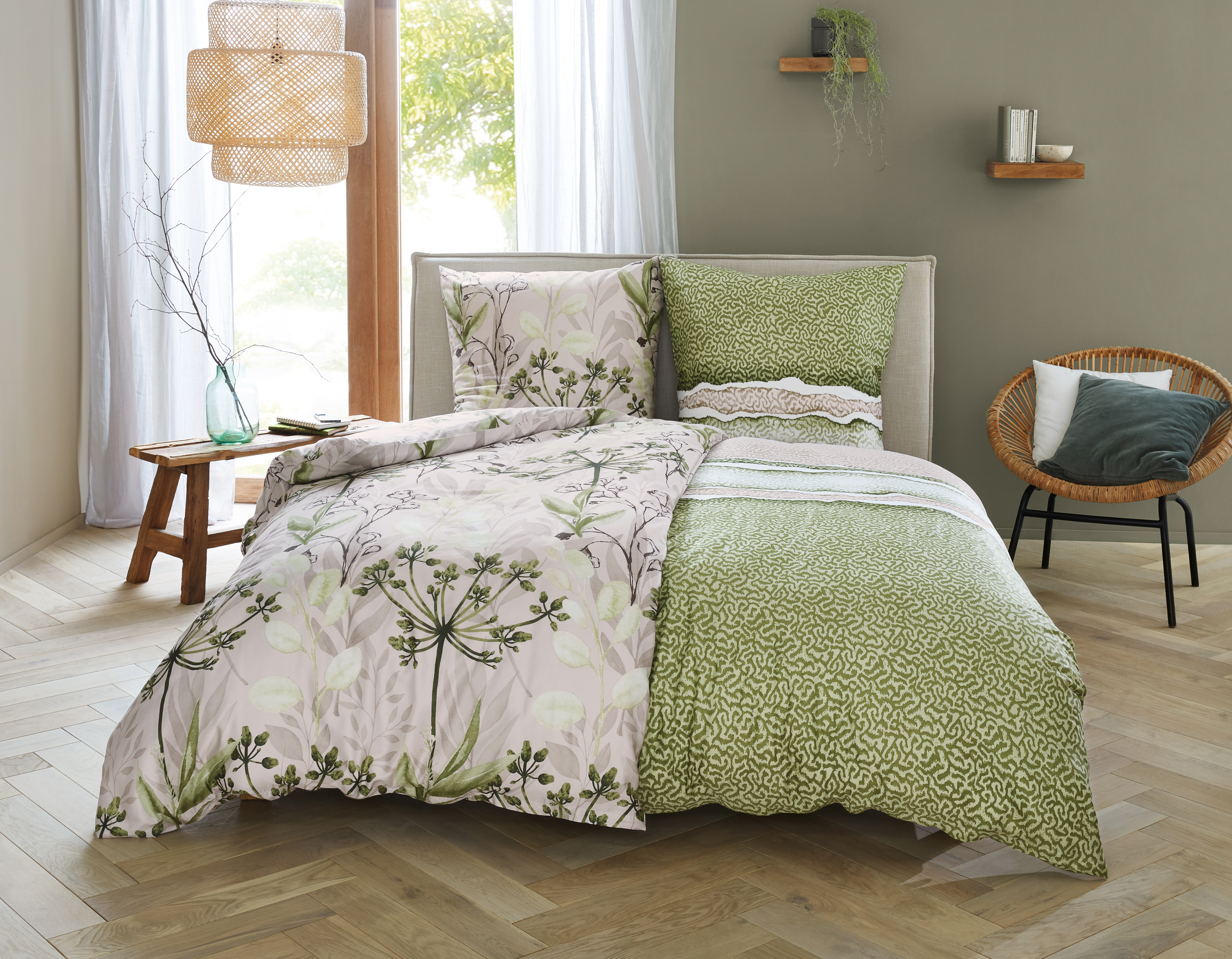 Bettwäsche-Set mit floralem und grünem Muster, dekoriert in einem modernen Schlafzimmer mit Holzmöbeln und Pflanzen.