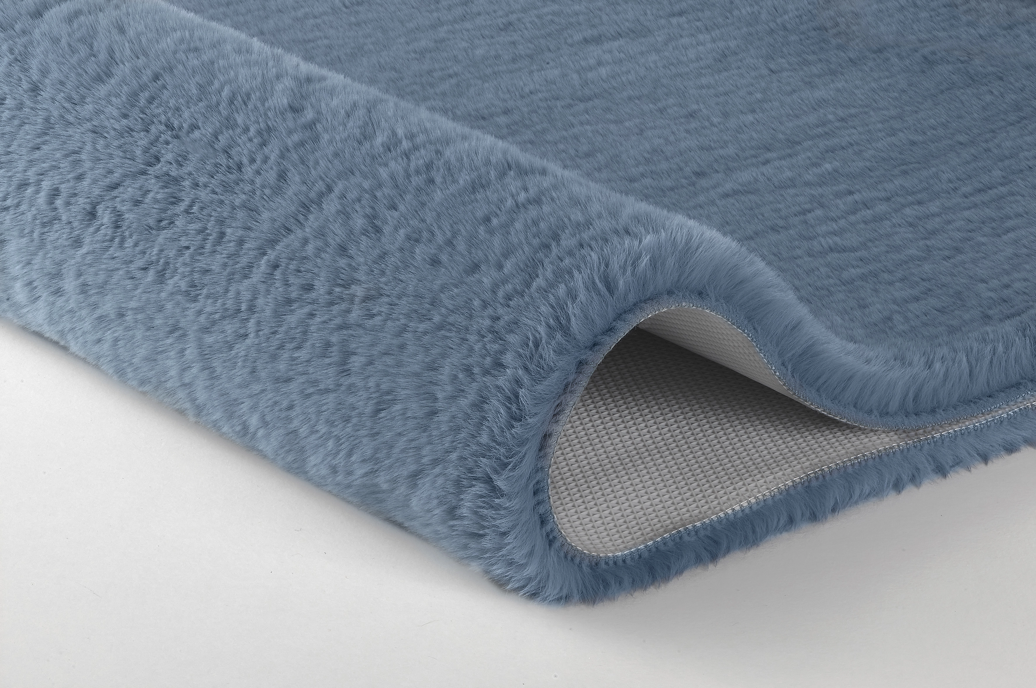 Weicher, hellblauer Teppich mit rutschfester Unterseite, ideal für Badezimmer oder Wohnräume.