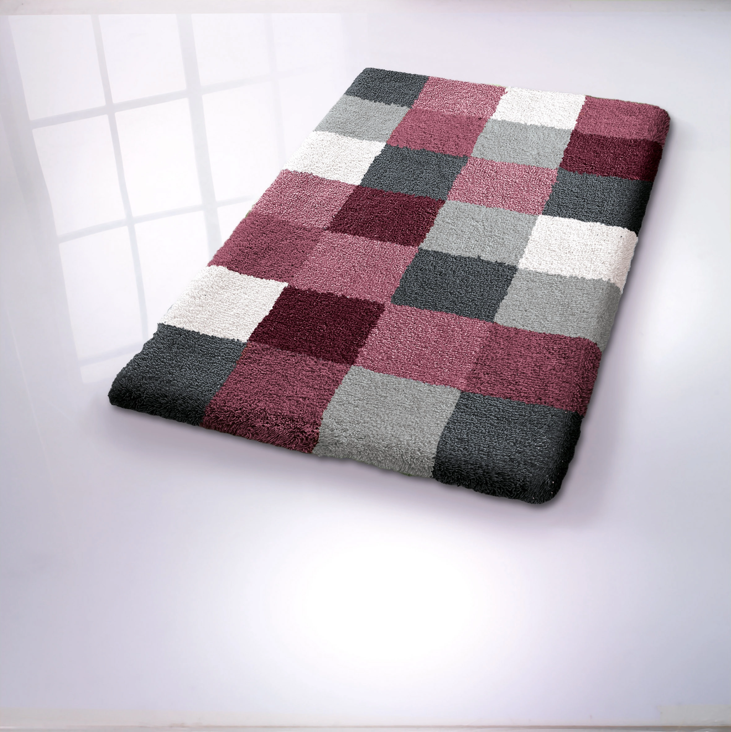 Bunter Badteppich mit Karomuster in Grau-, Weiß- und Rottönen, weiche Textur, ideal für moderne Badezimmer.