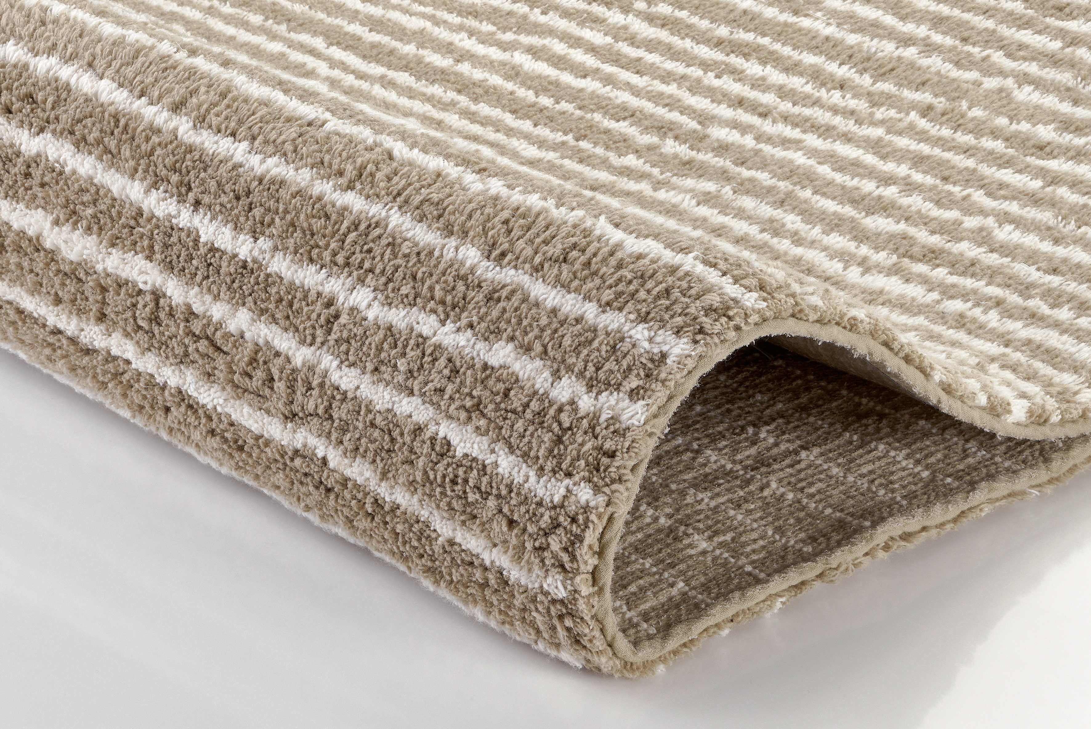 Beige-weißer Teppich mit Streifenmuster, weiche Textur, ideal für Wohn- und Schlafzimmer.