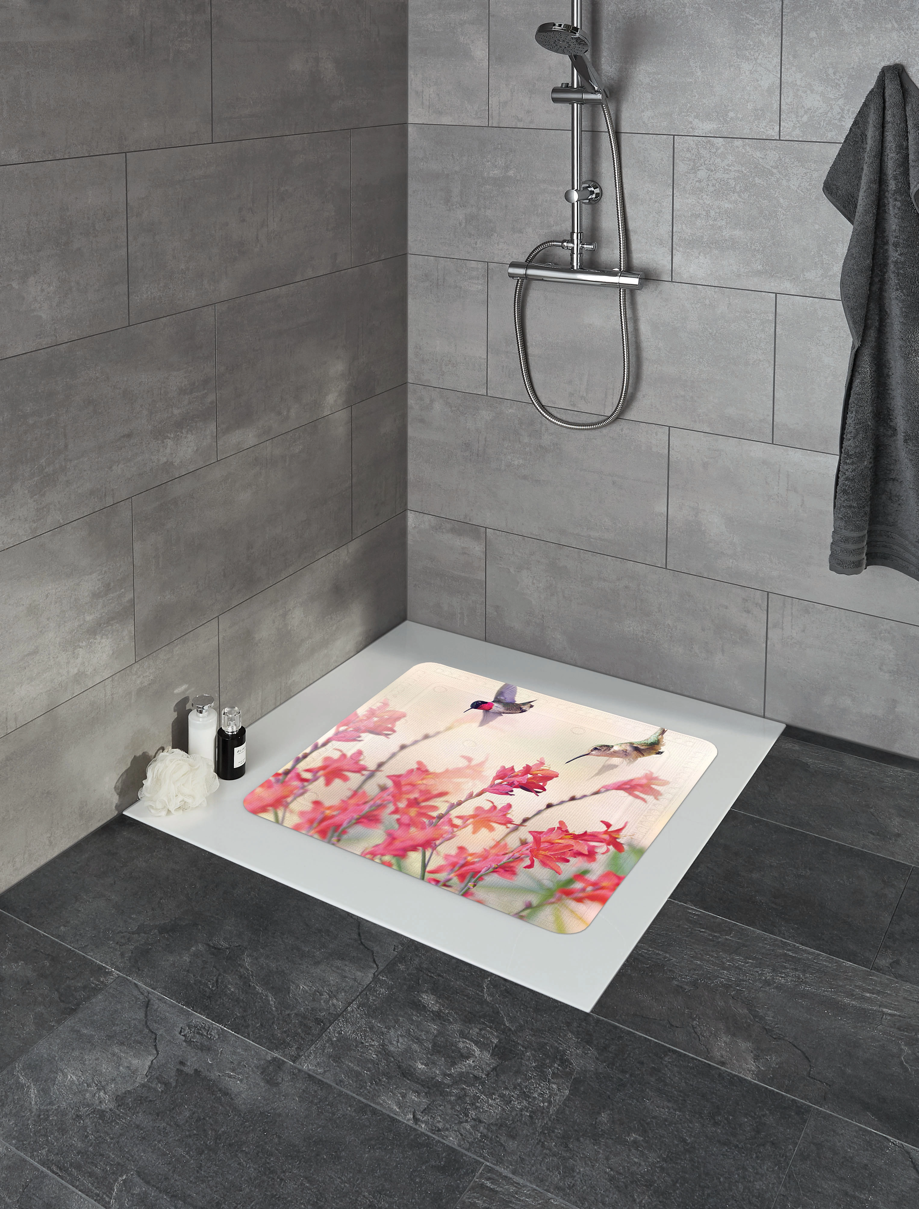 Duschmatte mit Kolibri- und Blumenmotiv in einer modernen grauen Badezimmerumgebung.
