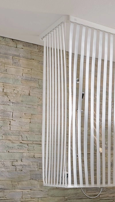 4004478223516 Duschvorhang mit weißen Streifen, modern und elegant, vor einer Steinwand montiert. Ideal für stilvolle Badezimmer.