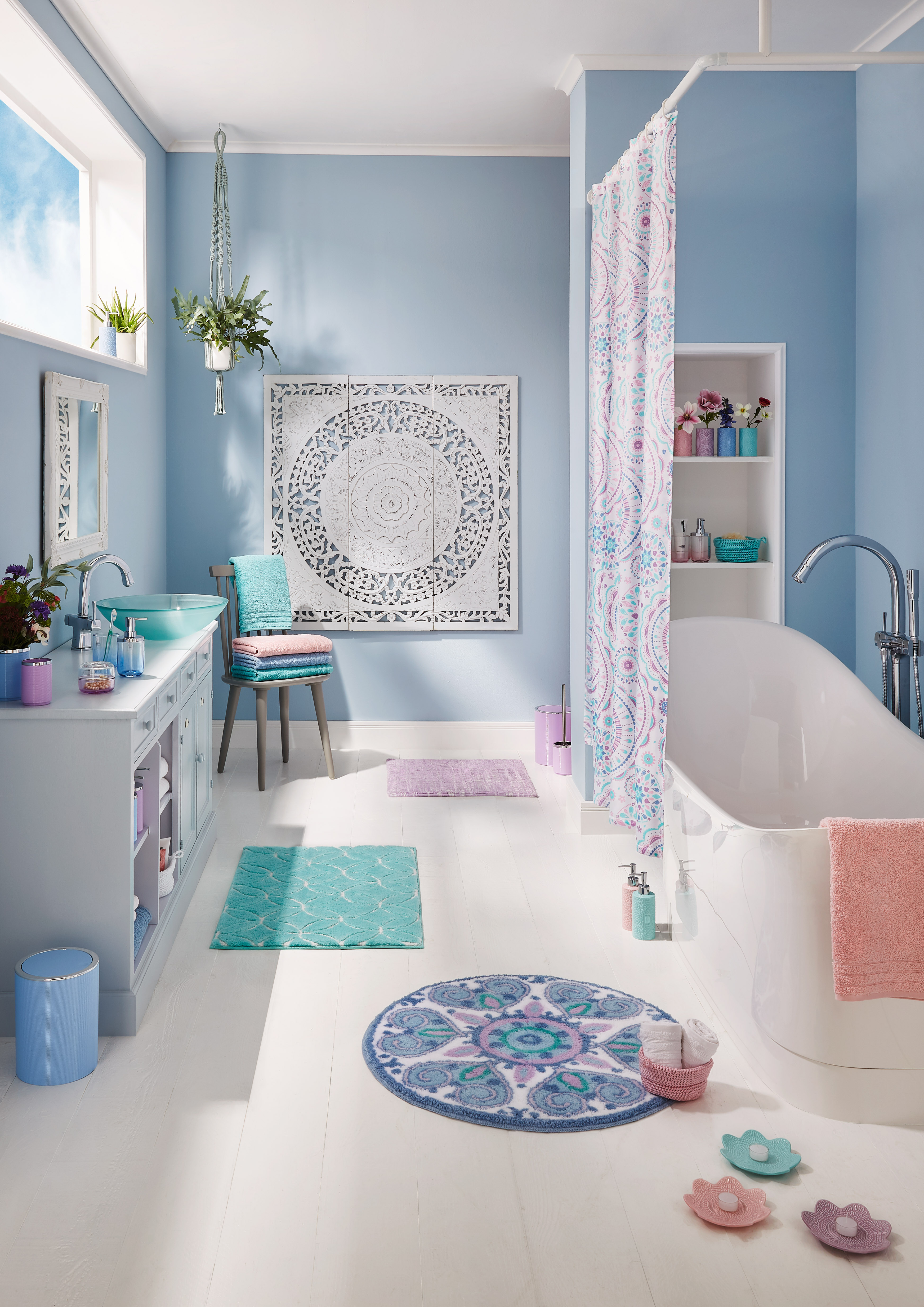 Modernes Badezimmer in Pastellfarben mit Badewanne, Duschvorhang, Teppichen und Pflanzen, dekoriert mit Mandala-Motiven.