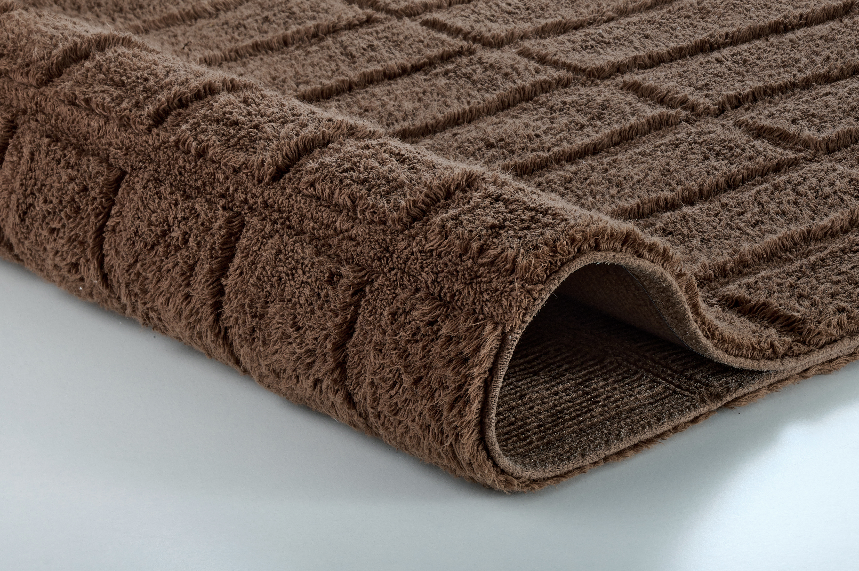 Brauner, flauschiger Badteppich mit rechteckigem Muster, weiche Textur, ideal für Badezimmer.