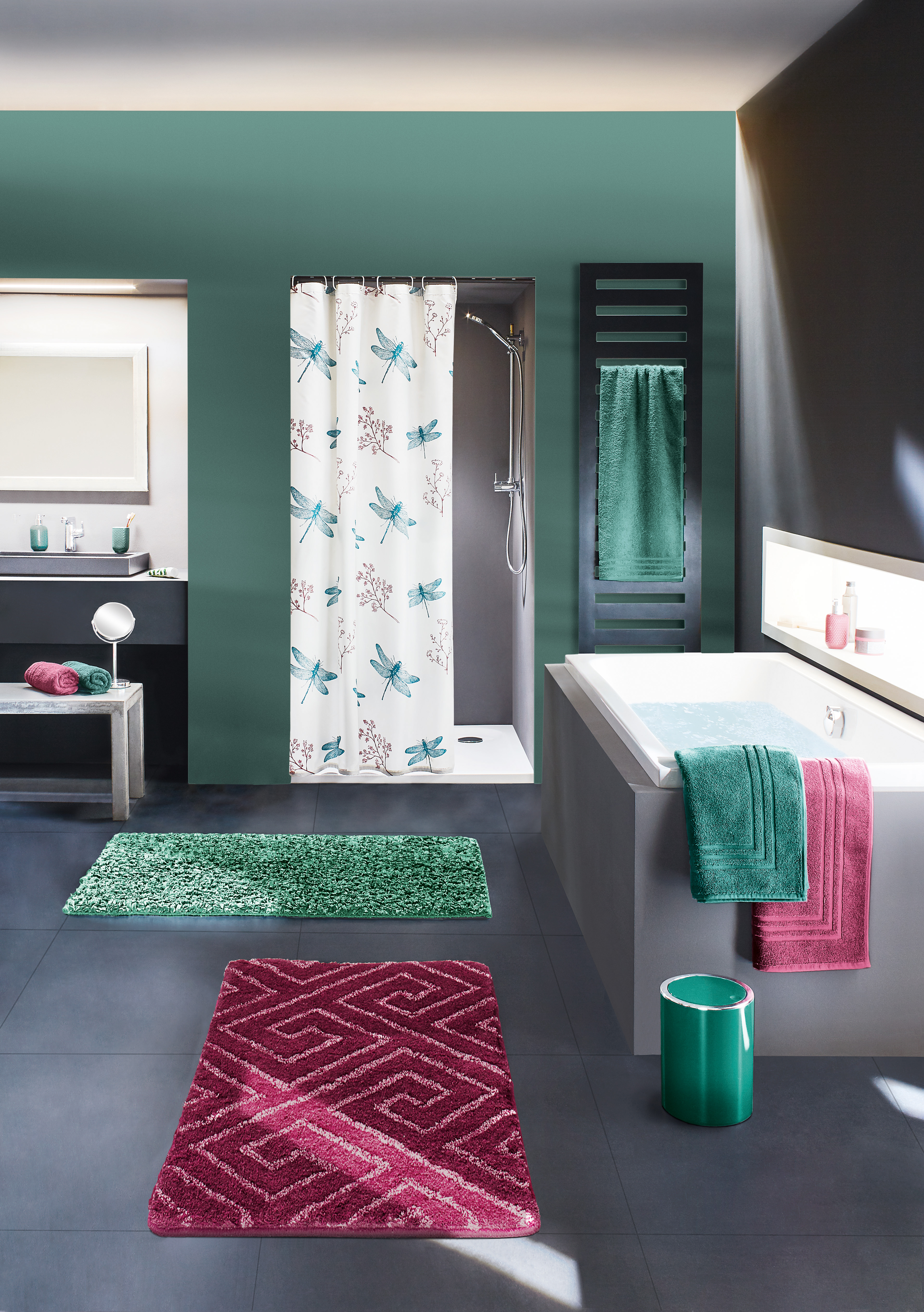 Modernes Badezimmer mit grünen und roten Badteppichen, Duschvorhang mit Libellenmuster, Handtüchern und stilvollen Accessoires.