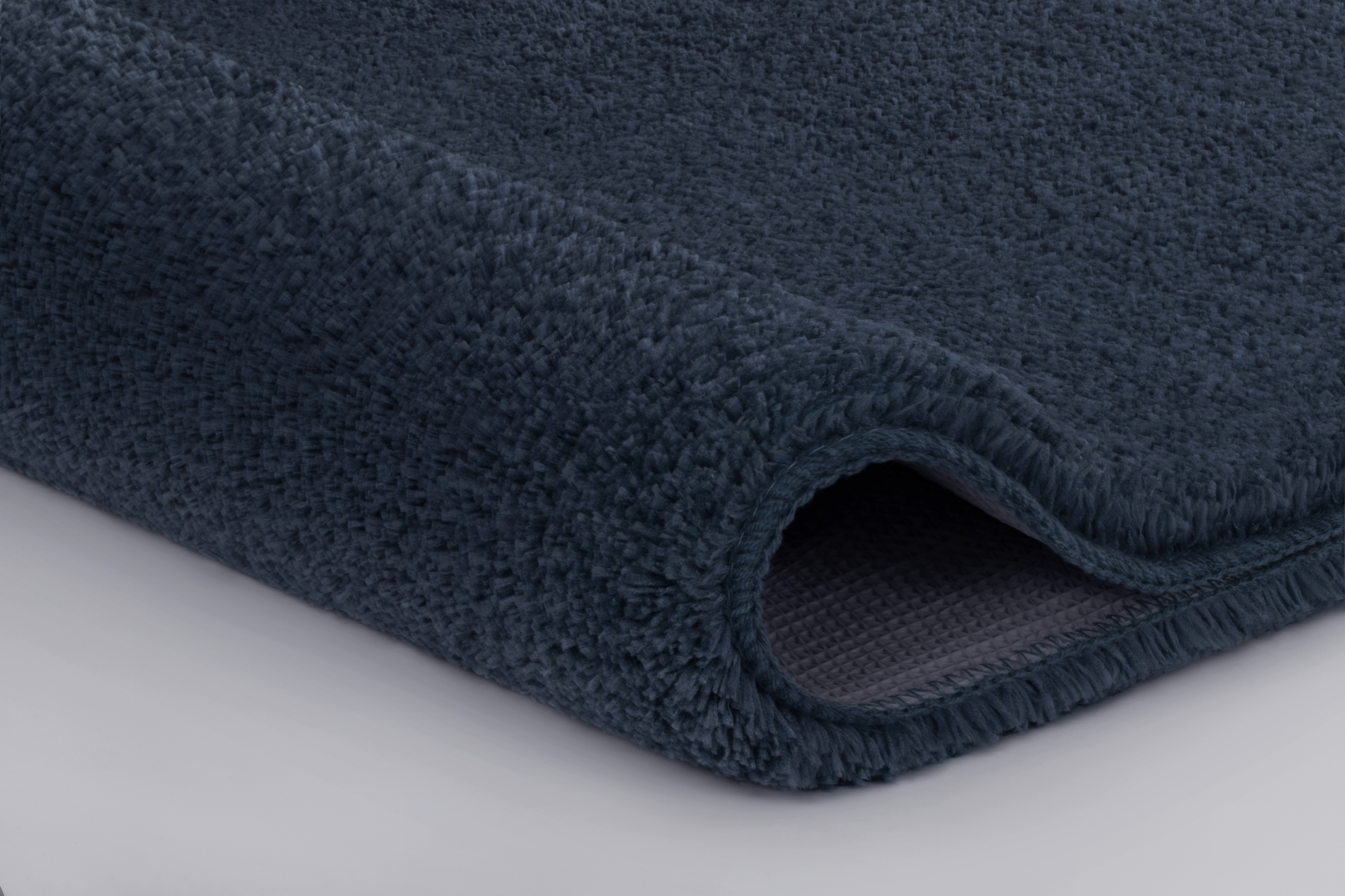 Weicher, dunkelblauer Badteppich mit rutschfester Unterseite, ideal für ein stilvolles und sicheres Badezimmer.