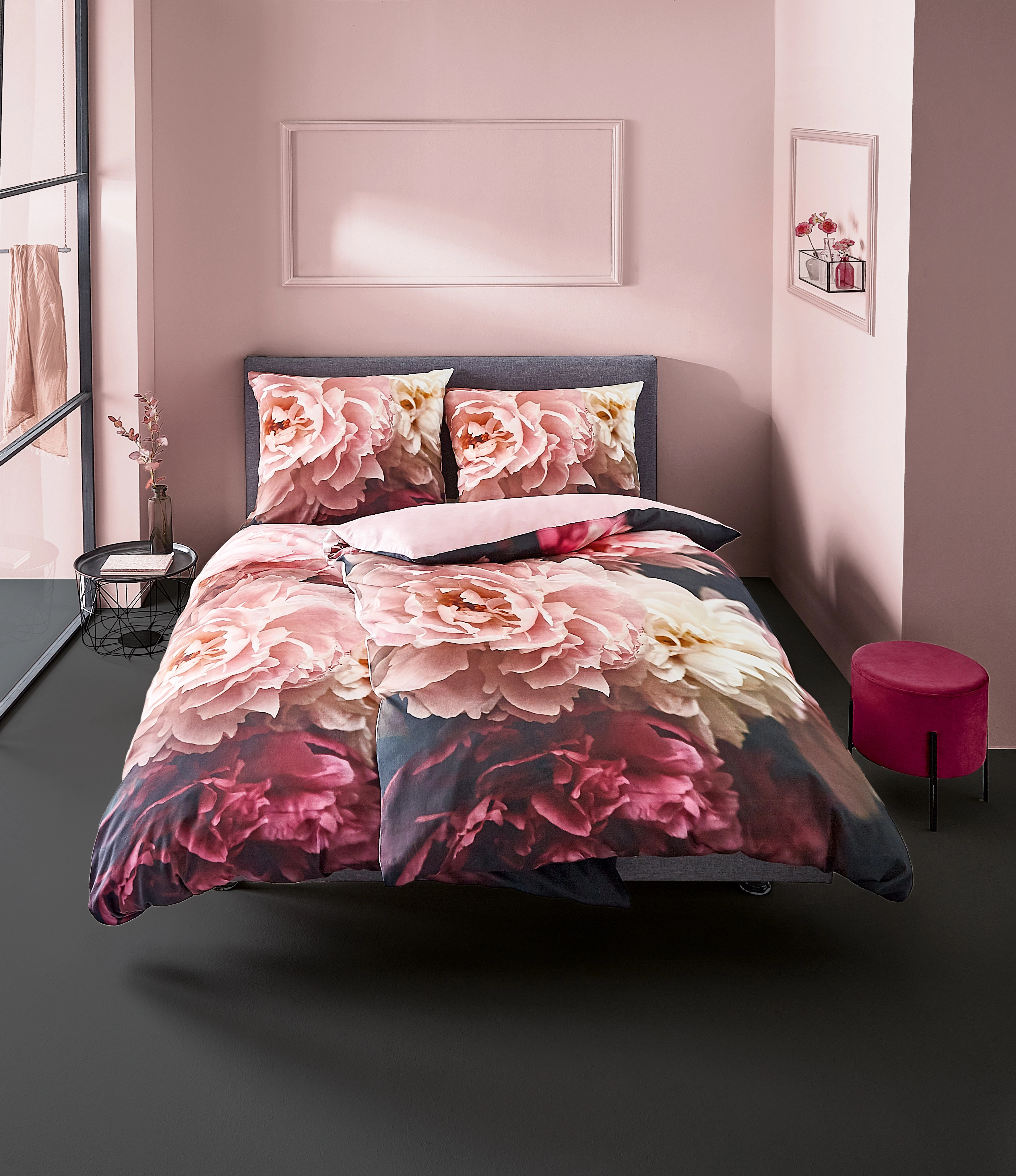 Bettwäsche-Set mit großem Blumenmuster in Rosa und Weiß, dekoriert in modernem Schlafzimmer mit rosa Wänden und schwarzem Boden.
