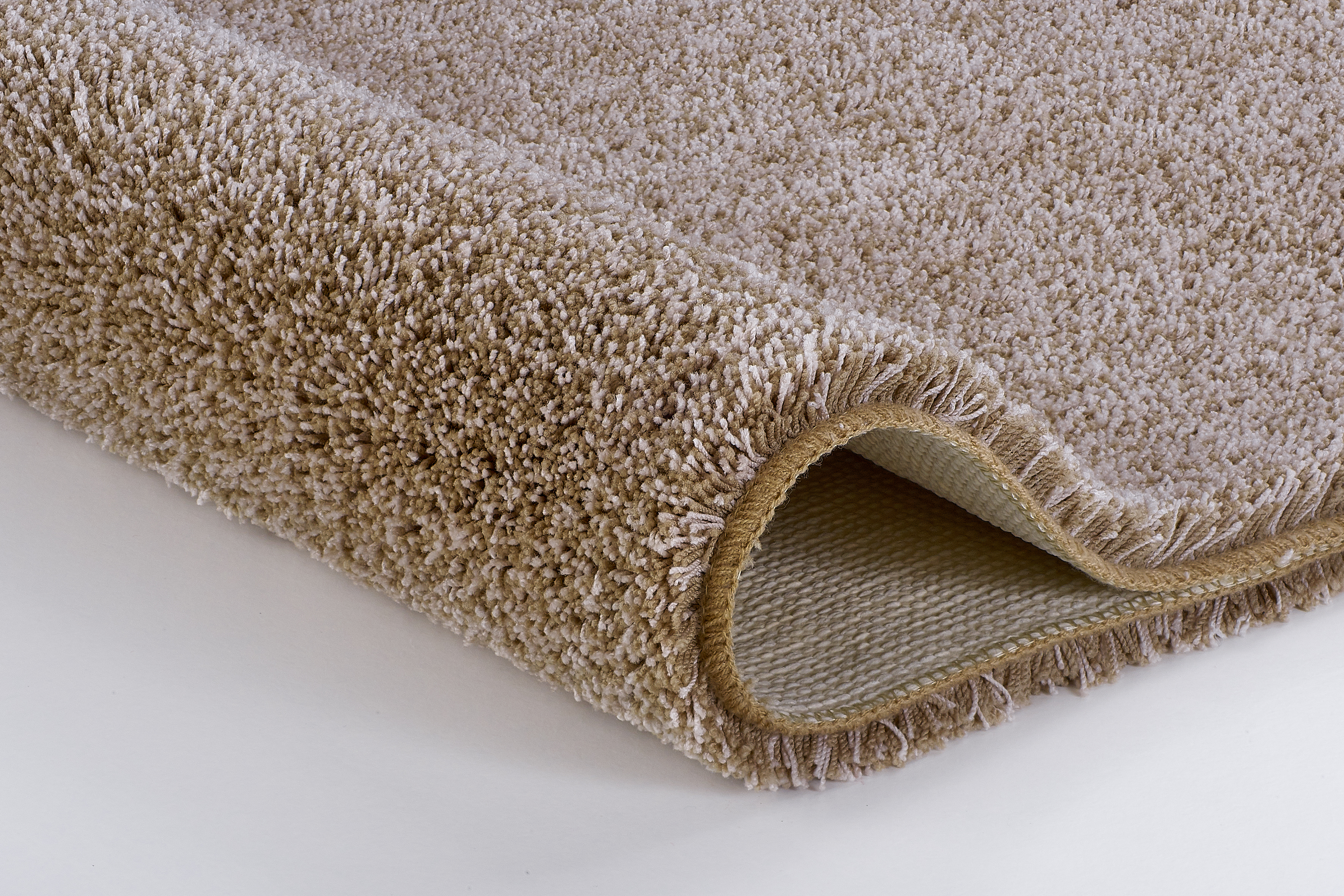 Beige Hochflor-Teppich mit weicher, flauschiger Oberfläche und rutschfester Rückseite, ideal für gemütliche Wohnräume.