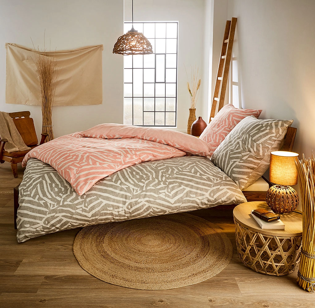 Bettwäsche-Set in modernem Design mit geometrischen Mustern in Beige und Rosa, gemütlich dekoriertes Schlafzimmer.