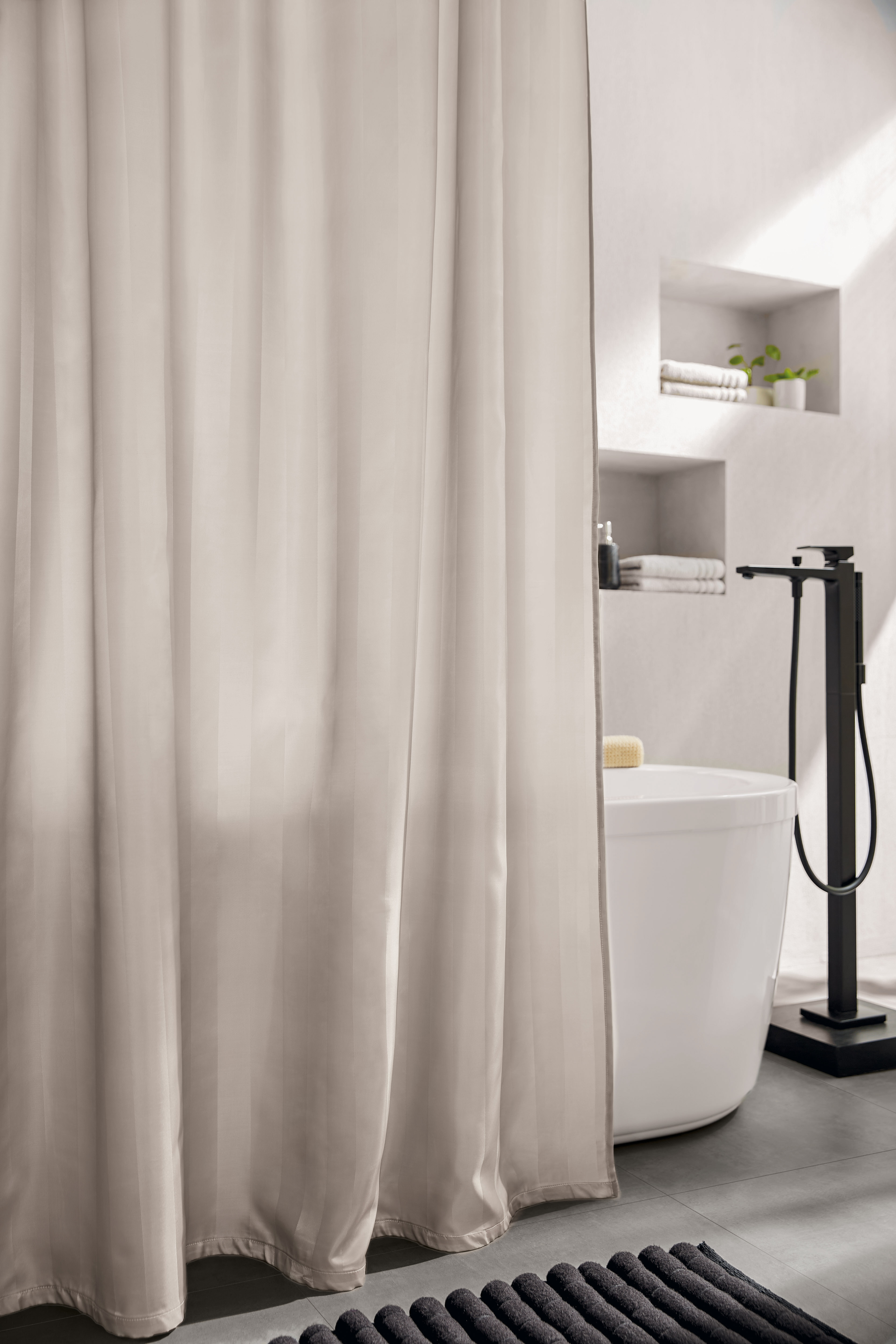 Eleganter Duschvorhang in Beige, der ein modernes Badezimmer mit freistehender Badewanne und stilvollen Regalen ergänzt.