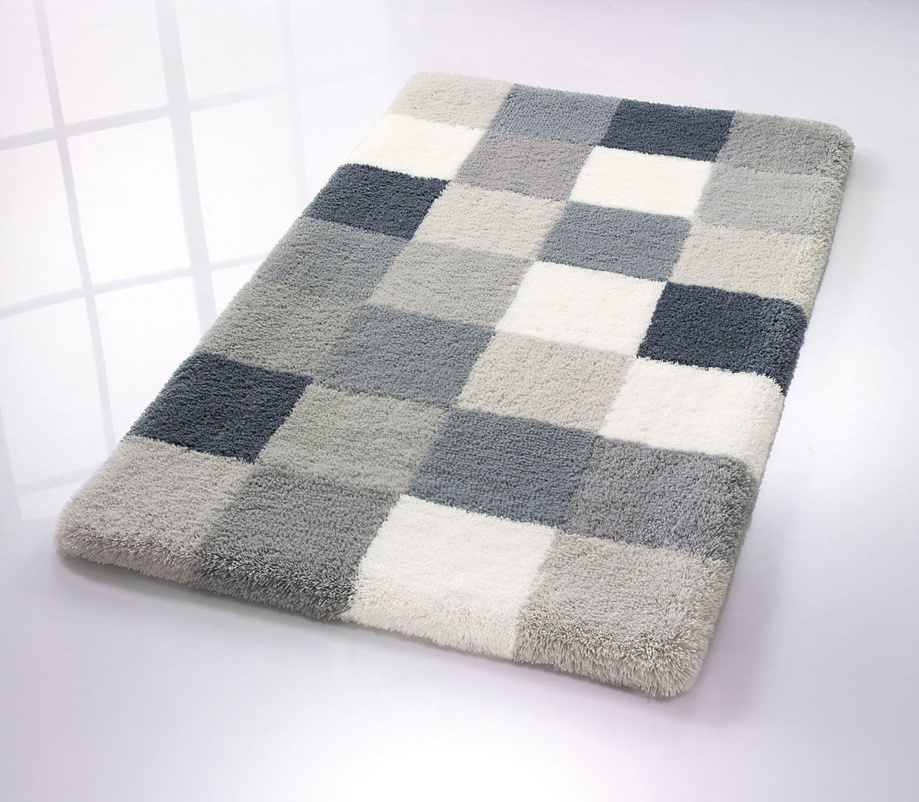 Badematte mit kariertem Muster in Grau- und Weißtönen, weiche Textur, ideal für moderne Badezimmer.