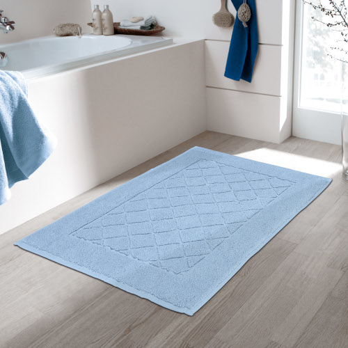 Hellblauer Badteppich mit rutschfester Rückseite, dekorativem Rautenmuster und weicher Oberfläche in modernem Badezimmer.