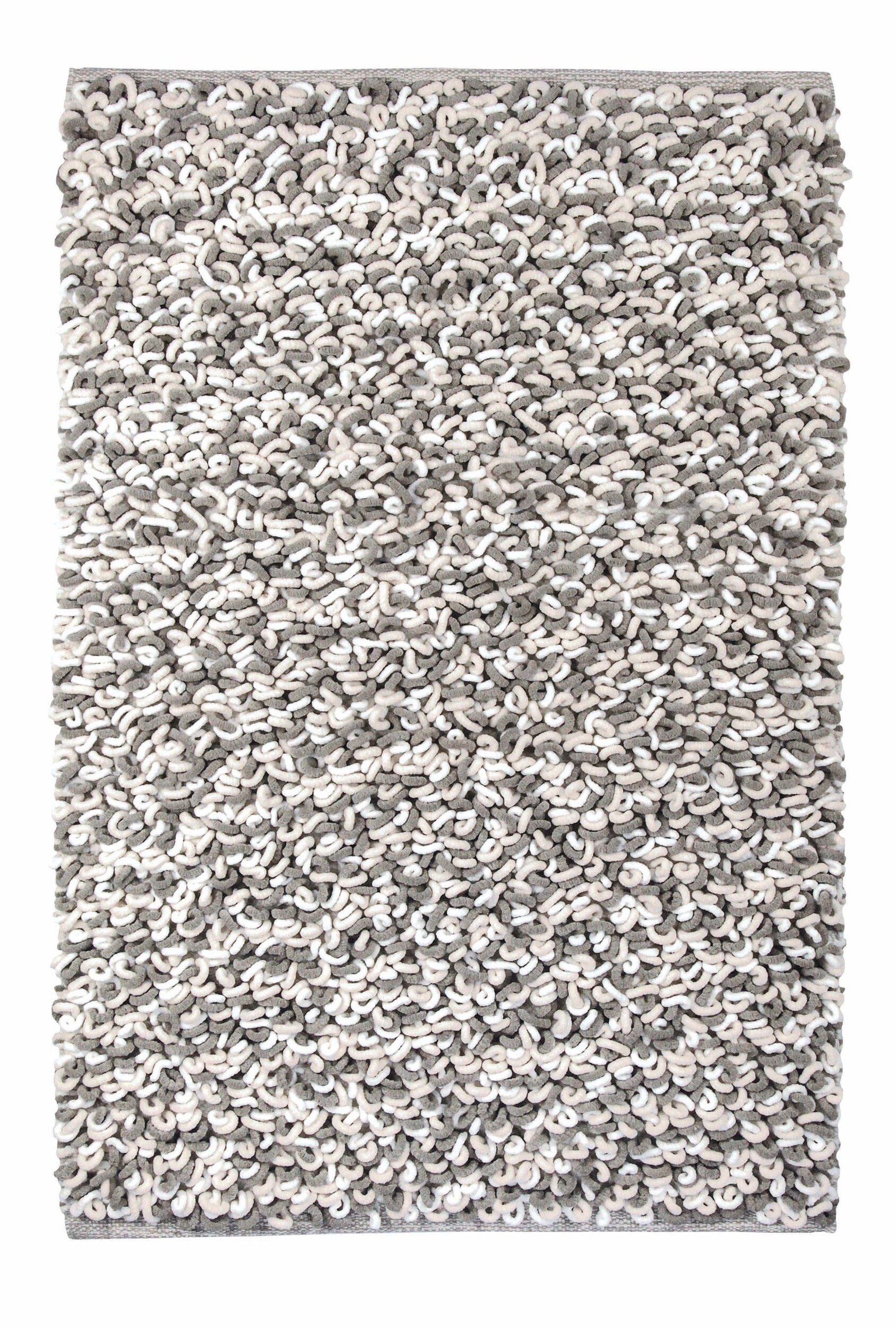 Badteppich SLING Macadamia 70 x 120 cm Grauer, flauschiger Badteppich mit dichter, strukturierter Oberfläche für ein modernes Badezimmer.