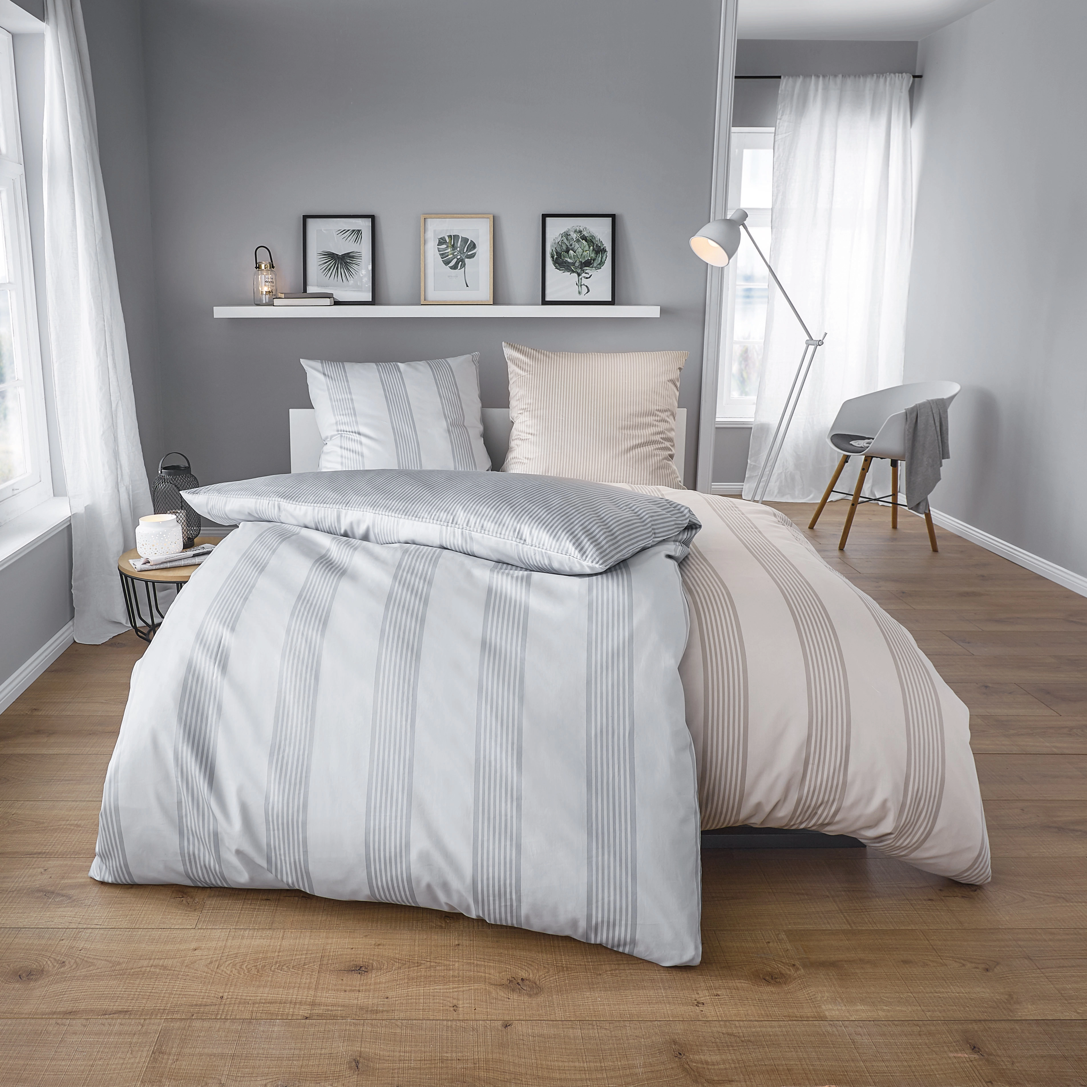 Elegante Bettwäsche in Grau und Beige mit Streifenmuster, modernes Schlafzimmer mit Holzfußboden und stilvoller Dekoration.