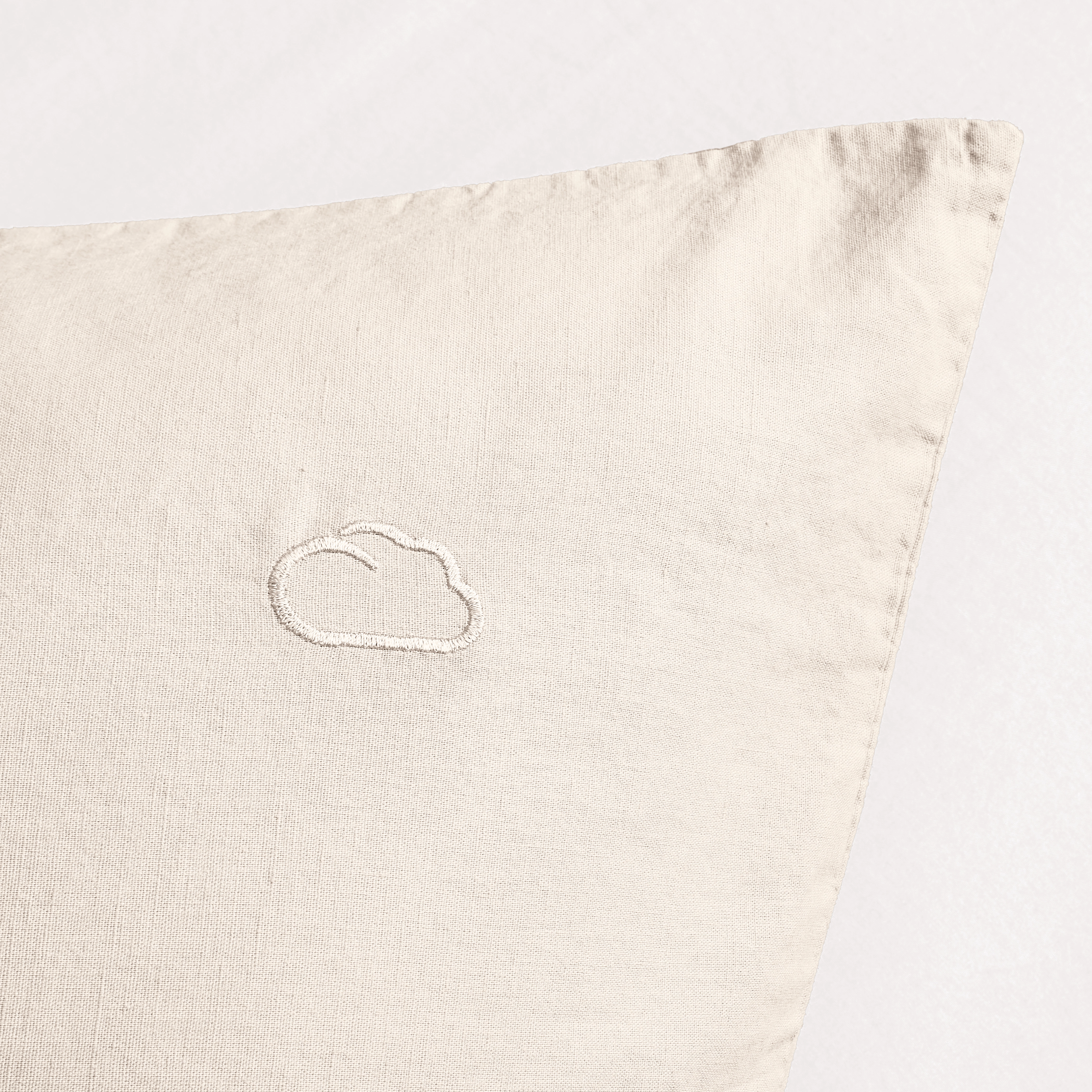 Beiges Kissen mit gesticktem Wolkenmotiv, minimalistisches Design, ideal für ein modernes und gemütliches Zuhause.