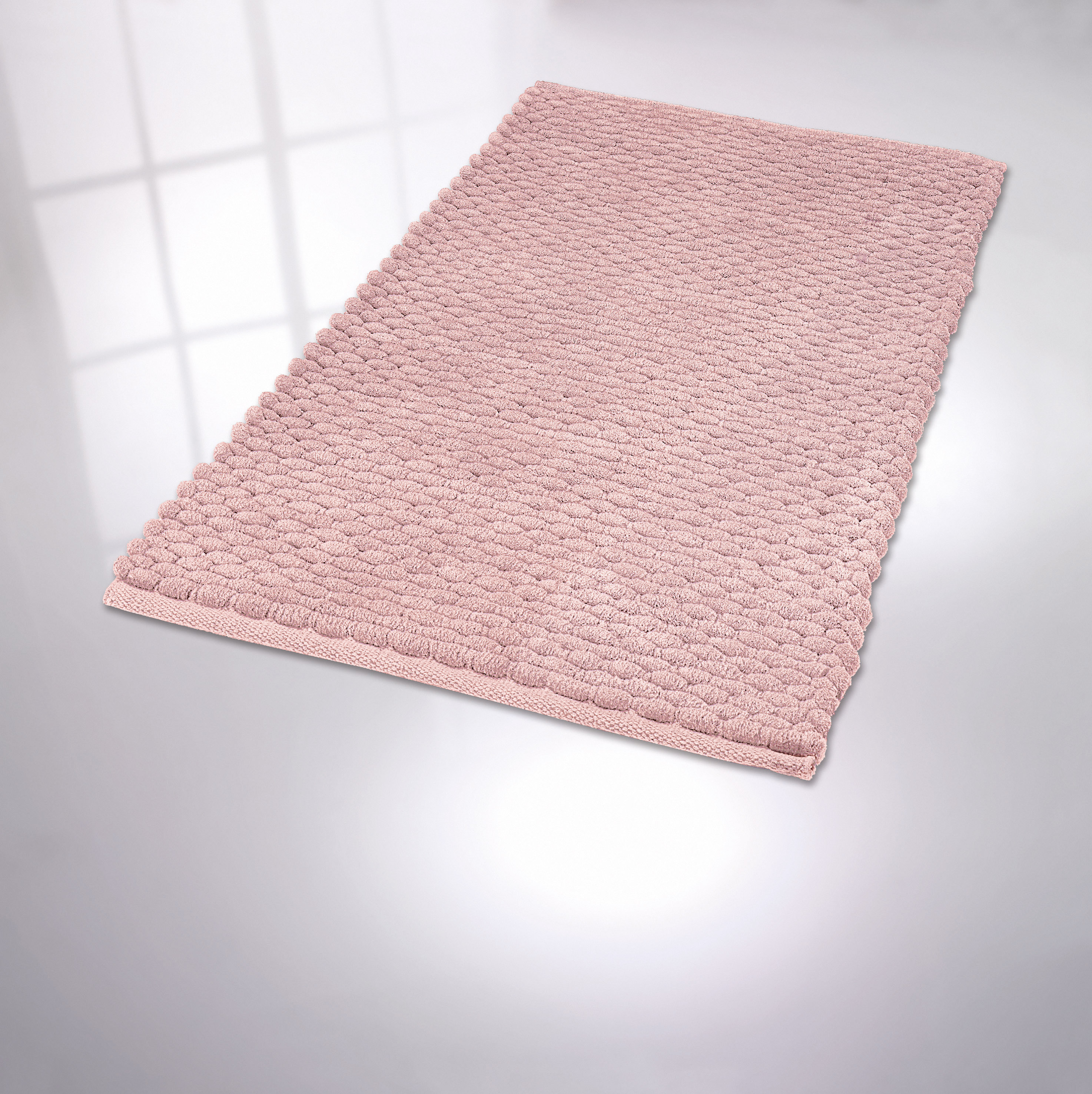 Weicher, rosafarbener Badteppich mit strukturierter Oberfläche, ideal für ein gemütliches und stilvolles Badezimmer.