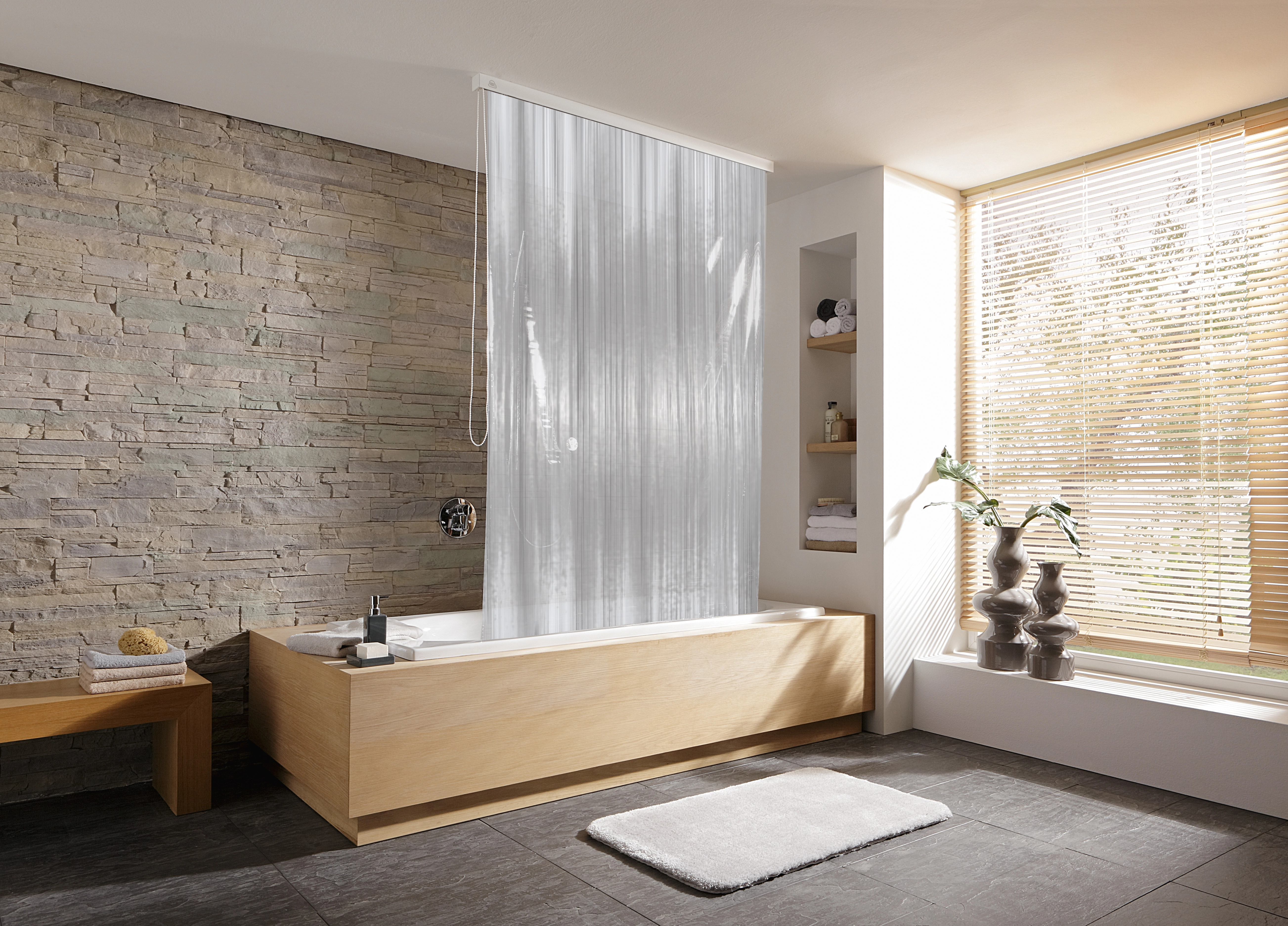 Moderne Badewanne mit Holzverkleidung, Duschvorhang, Steinwand, Fenster mit Jalousien, Pflanzen und Handtüchern.