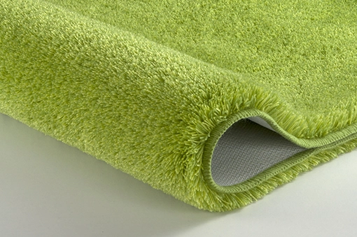 Grüner, flauschiger Badteppich mit rutschfester Unterseite, ideal für ein gemütliches und sicheres Badezimmer.