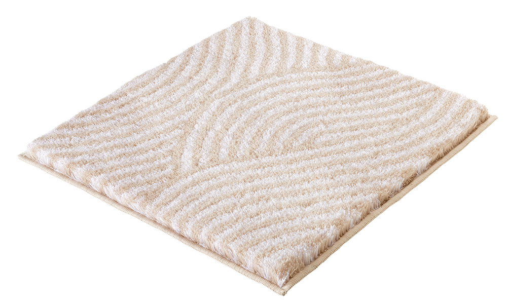 Weicher, cremefarbener Badteppich mit wellenförmigem Muster, ideal für ein stilvolles und gemütliches Badezimmer.