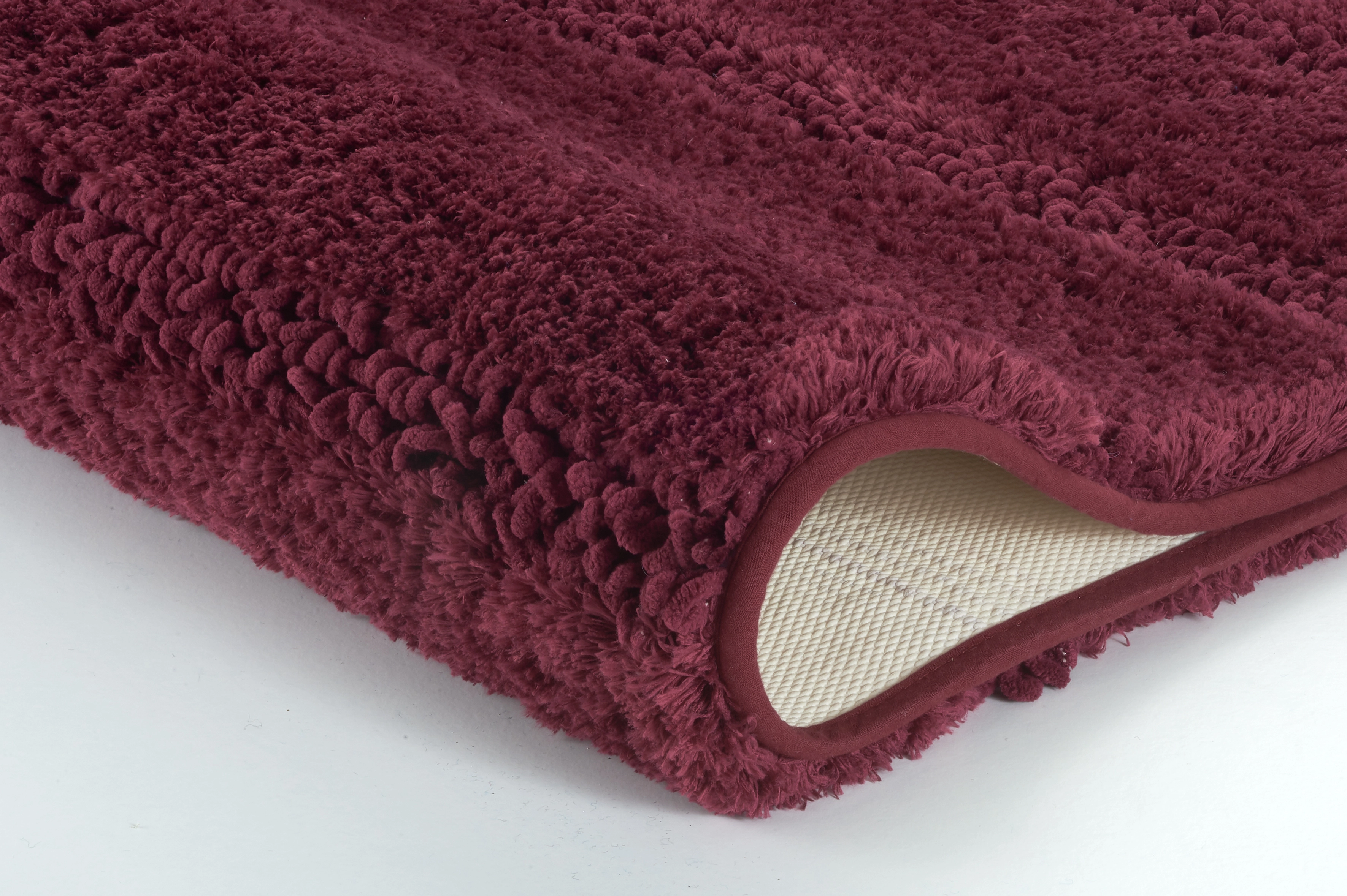 Weinroter, flauschiger Badteppich mit rutschfester Unterseite für sicheren Halt und Komfort im Badezimmer.